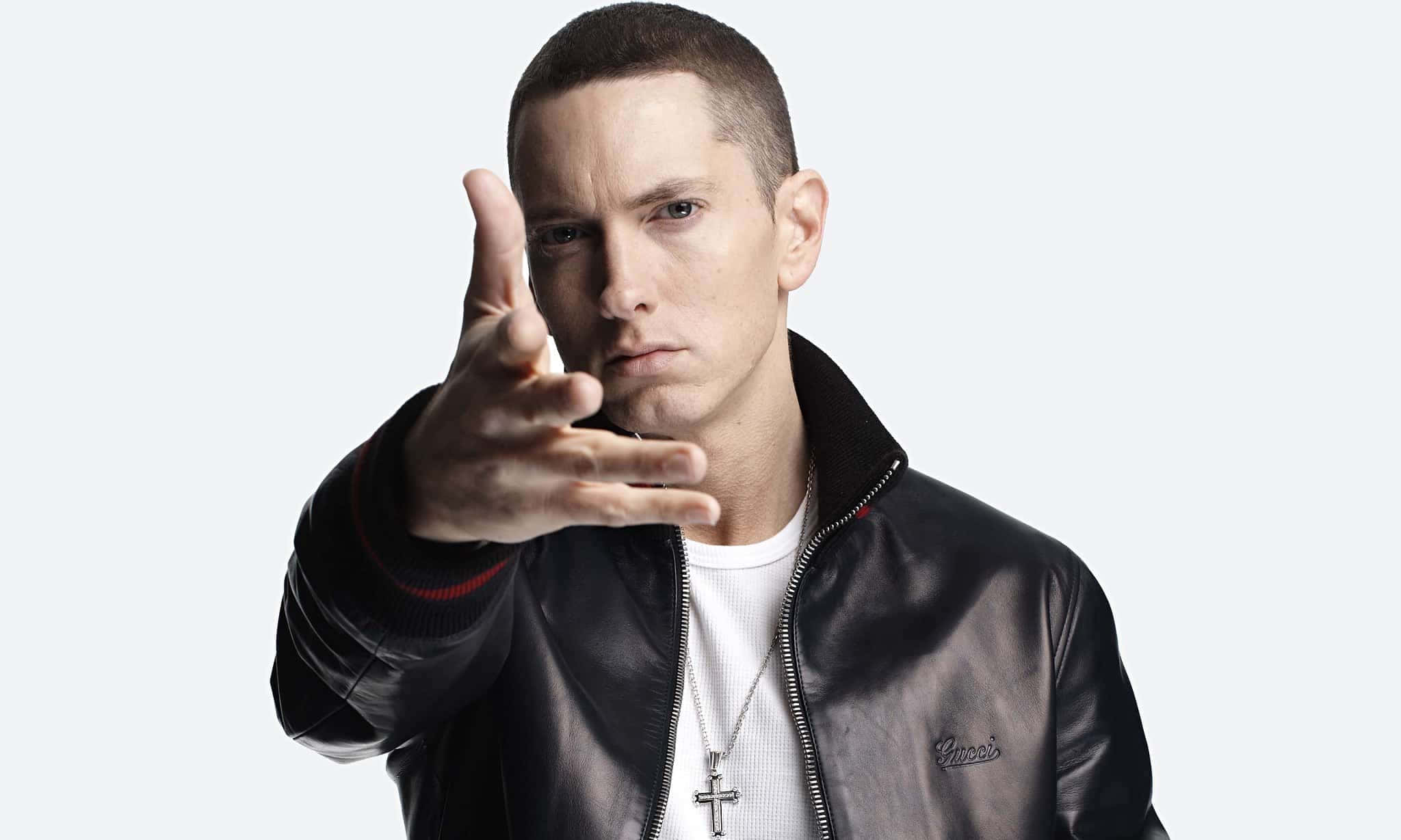 Eminem 桌布 壁紙 — Eminem 將手向前伸出，在純淺灰色背景下強烈凝視鏡頭。