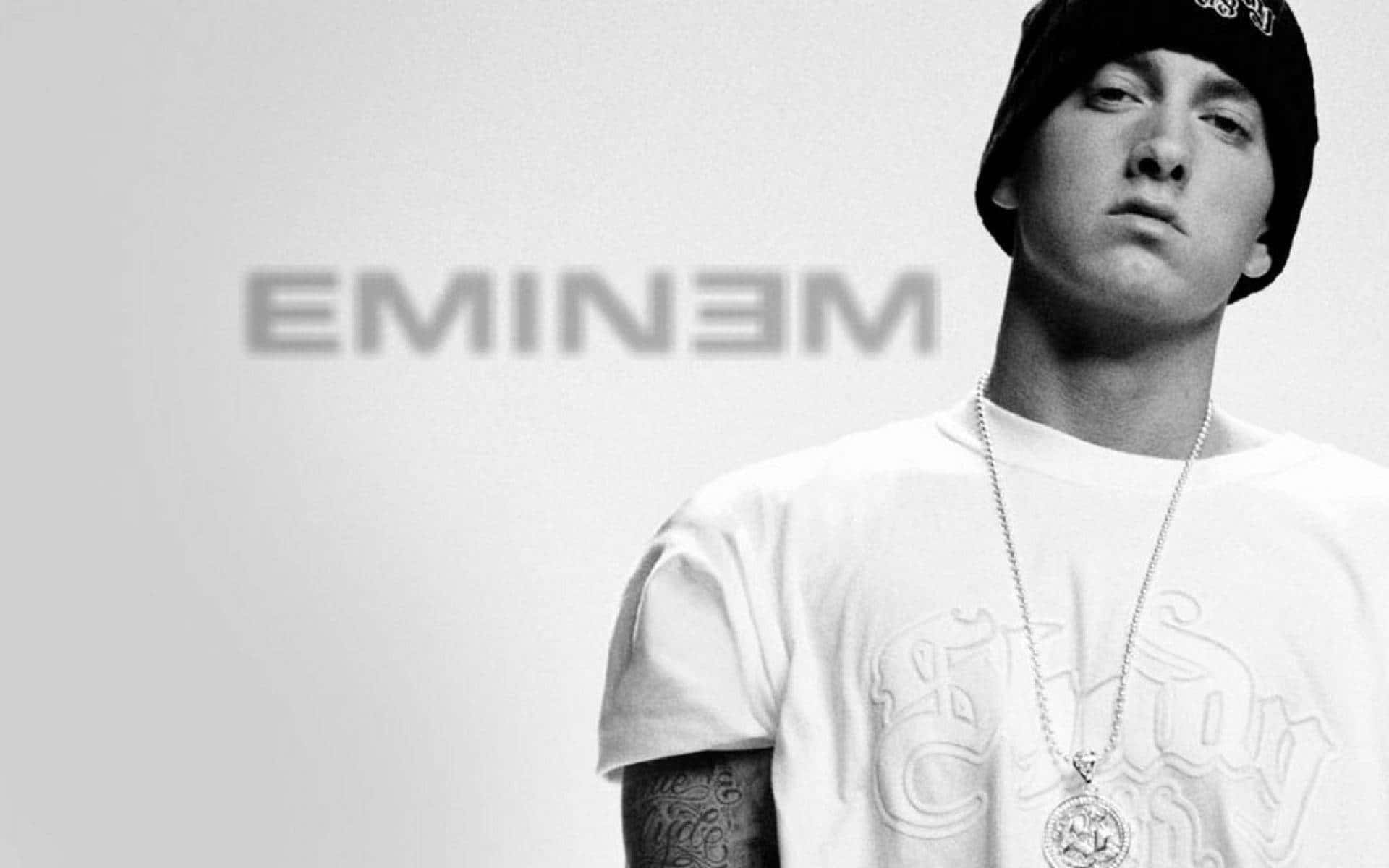 Eminem 桌布 壁紙 — Eminem 的黑白肖像，戴著冷帽和鏈條，背景簡潔，他的名字模糊地出現在身後。