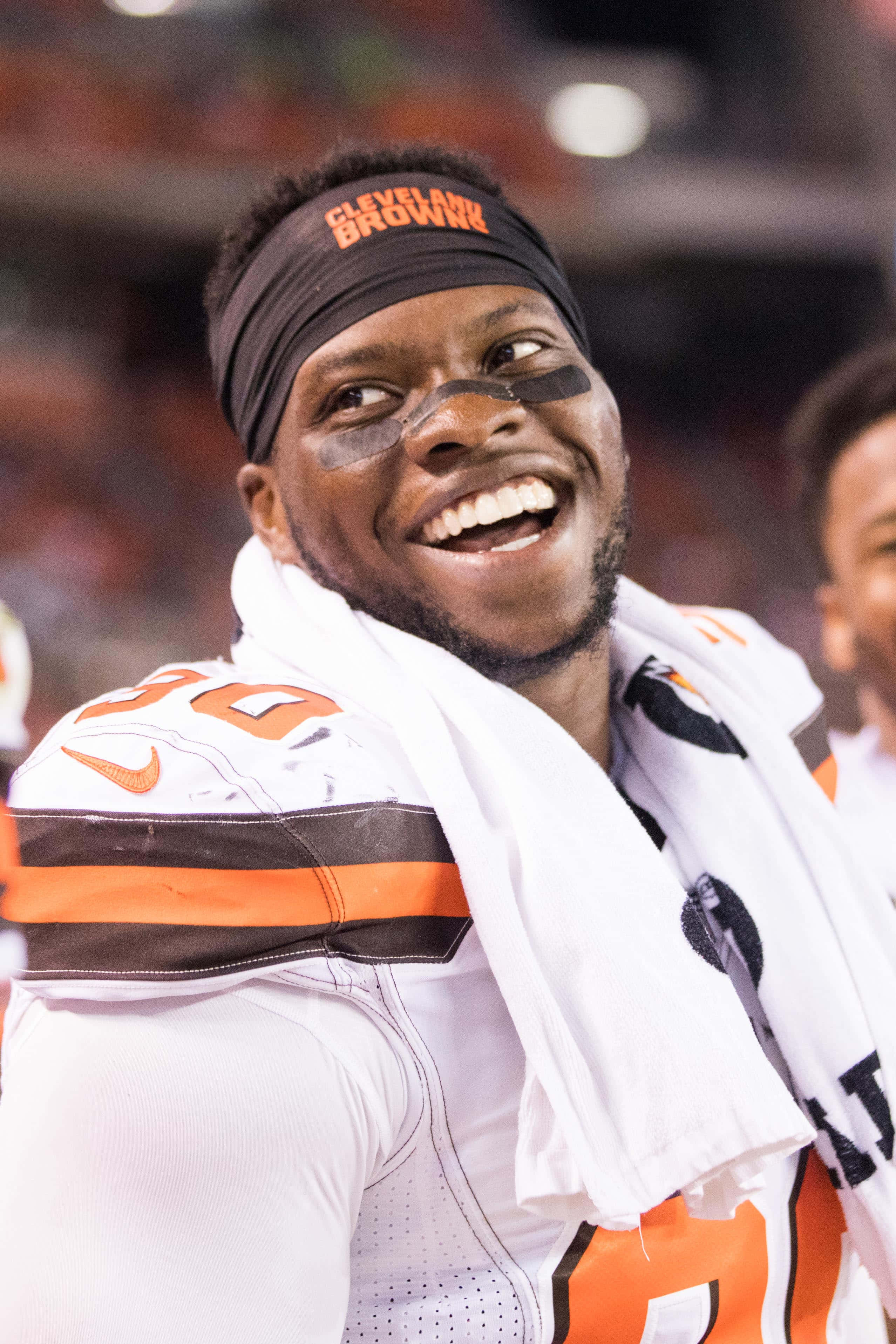Emmanuel Ogbah 美式足球員賽後肖像 壁紙 — 一位克里夫蘭布朗隊的足球員在球場上穿著球隊裝備和眼黑，滿臉喜悅。