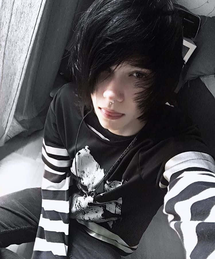 感受真實的emo風格氛圍 壁紙 — 一個黑髮戴鼻環嘅人喺床上放鬆，著住黑白間條衫。
