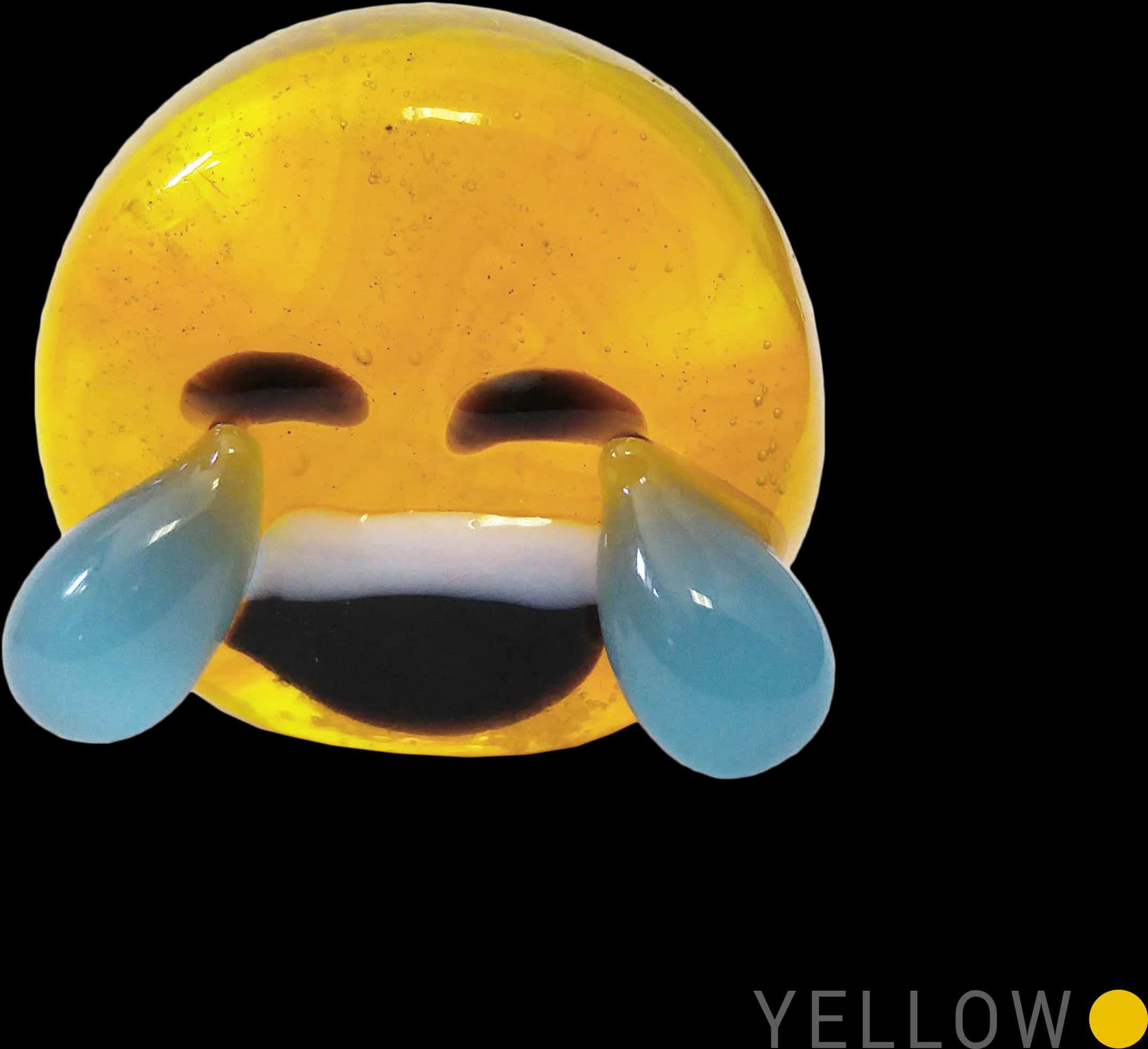 哭泣笑臉黃色Emoji 壁紙 — 一個光澤的黃色大笑表情符號，帶有由半透明凝膠製成的藍色眼淚，在黑色背景上。