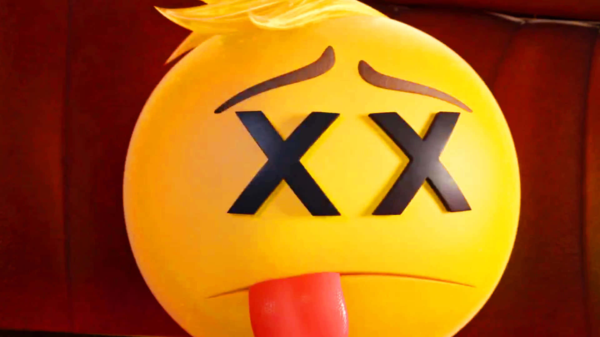 《Emoji電影》中巨大的傷心Emoji 壁紙 — 一個大型黃色表情符號，眼睛呈X形，舌頭伸出，背景為深紅色。