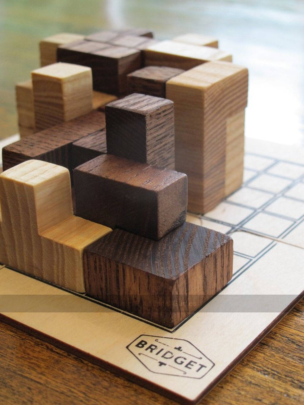 木製拼圖塊放在有明顯木紋和刻有標誌的品牌遊戲板上。