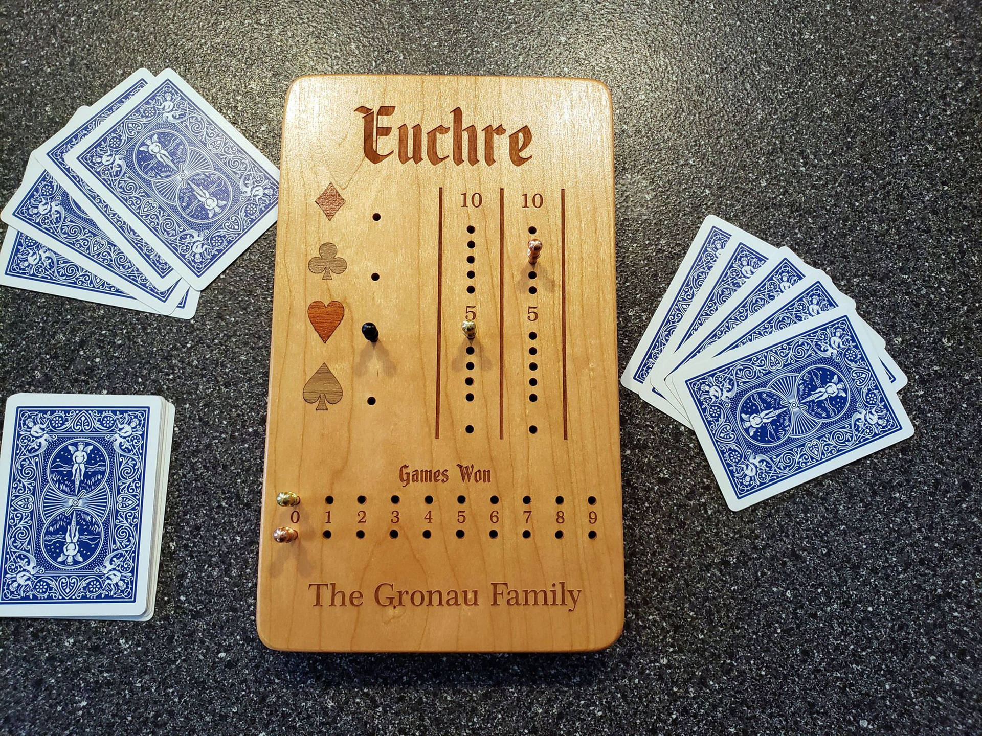 個人木製尤克爾遊戲得分板，檯面上有藍色撲克牌。
