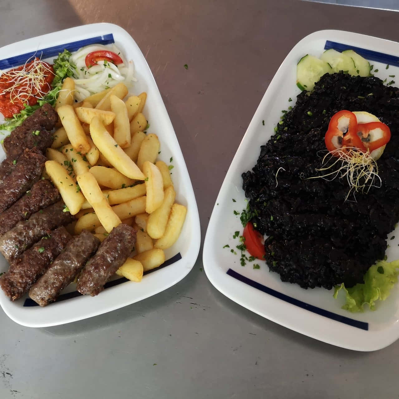 Ćevapi香腸與黑意麵 壁紙 — 兩盤餐點，包括香腸和薯條，以及一道搭配蔬菜和芽菜的深色肉類菜餚。