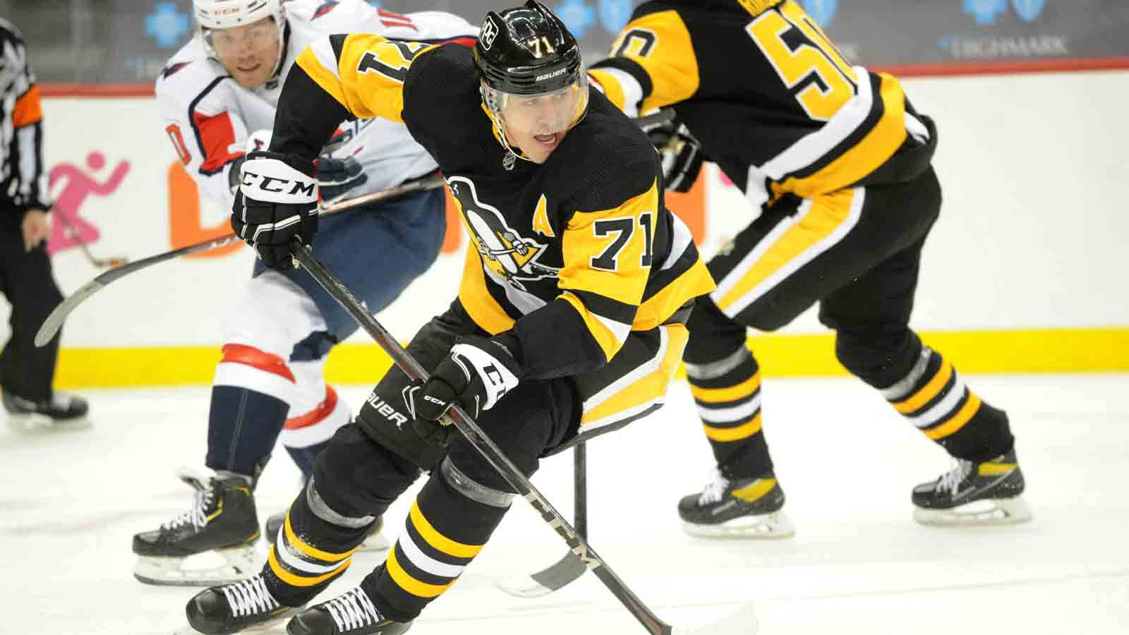 Evgeni Malkin 匹茲堡企鵝隊盜取冰球 壁紙 — 身穿黑色和黃色球衣、號碼71的冰球運動員在快節奏比賽中，在冰上激烈前傾，對手就在附近。