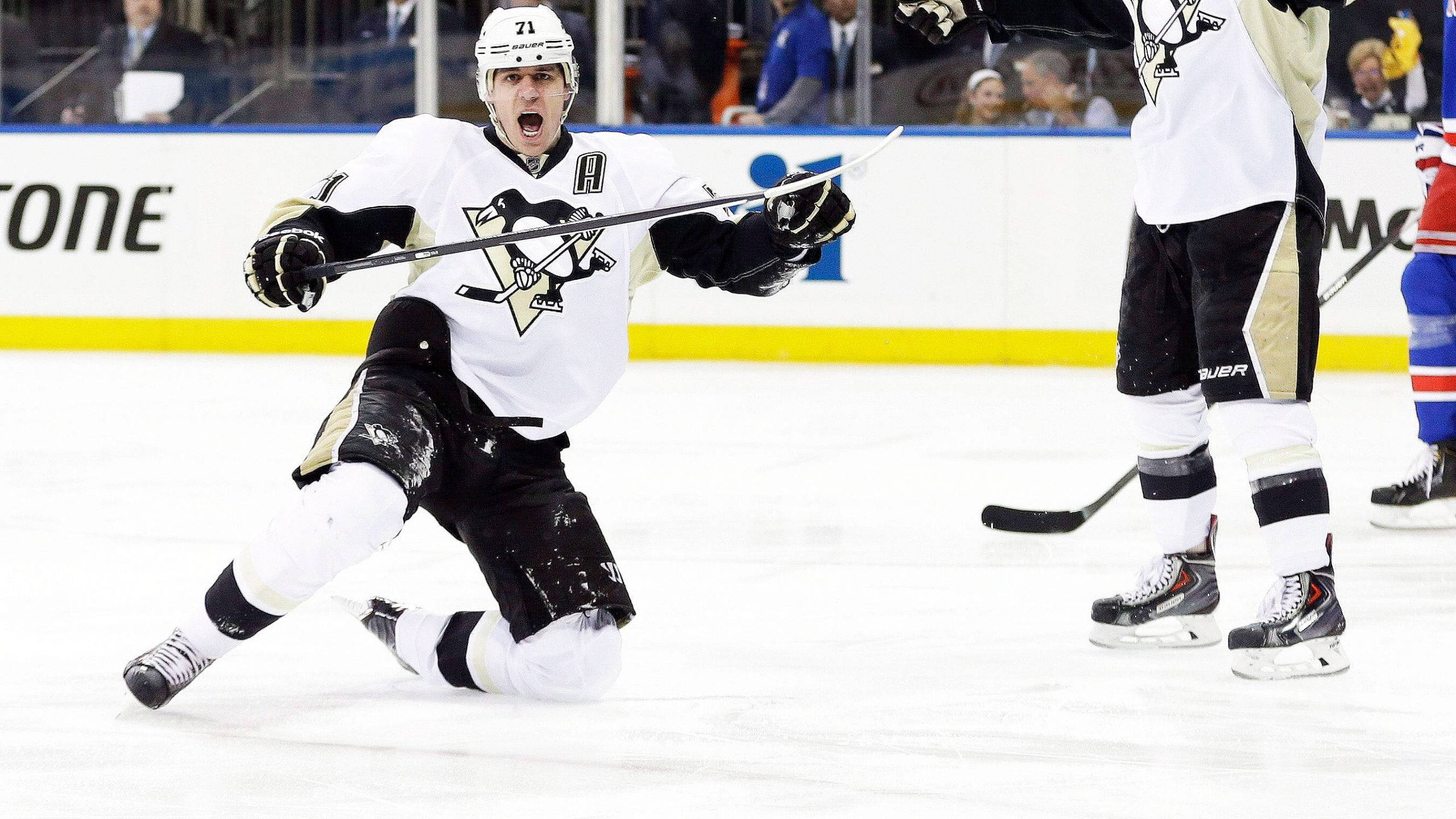 Evgeni Malkin 高興慶祝跪地 壁紙 — 一名身穿黑白球衣的冰球運動員在冰上張開雙臂、張開嘴巴慶祝入球。