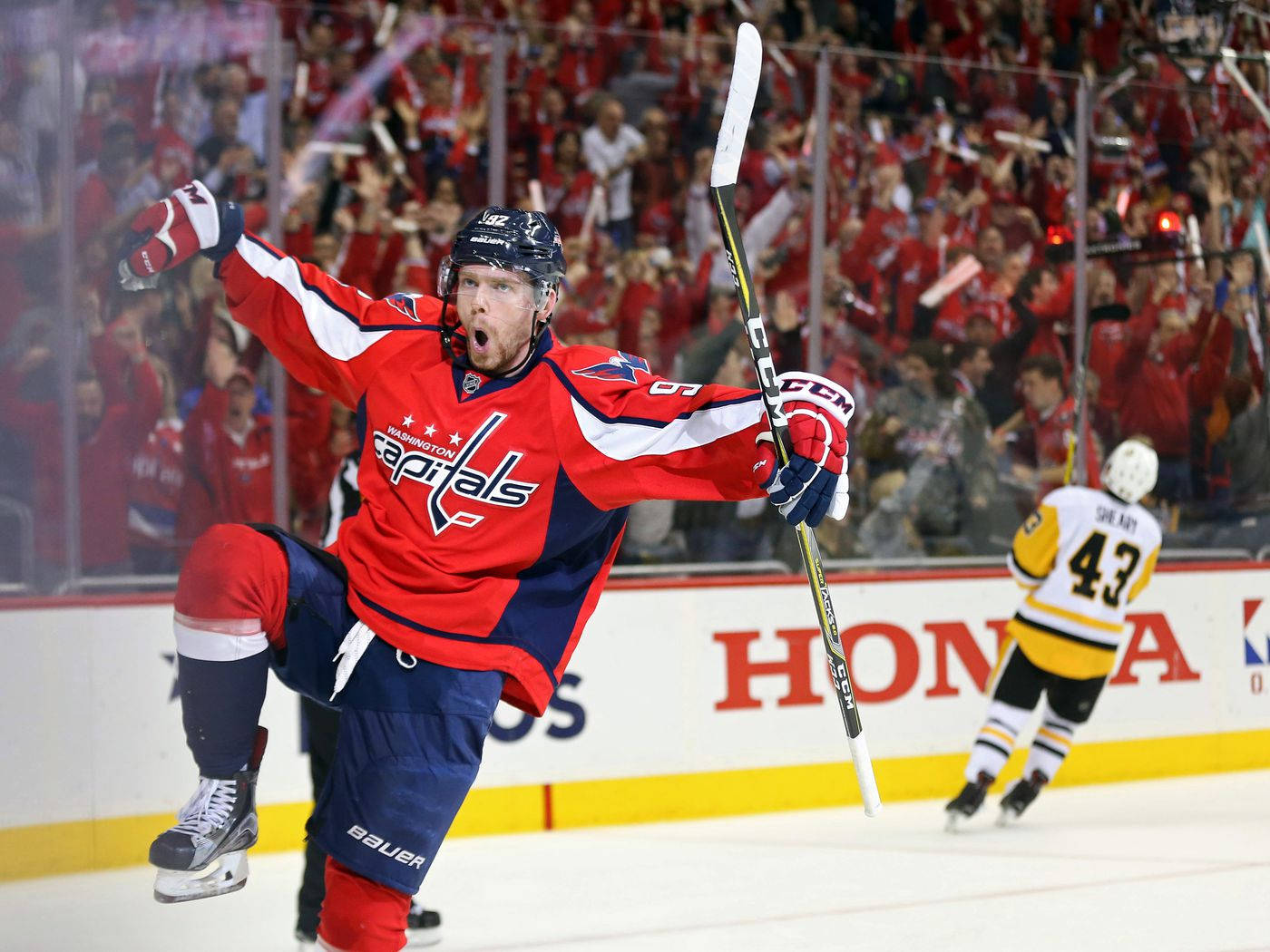 Evgeny Kuznetsov 勝利舞蹈 壁紙 — 華盛頓首都隊冰球運動員在冰上高舉雙臂和球桿慶祝入球。