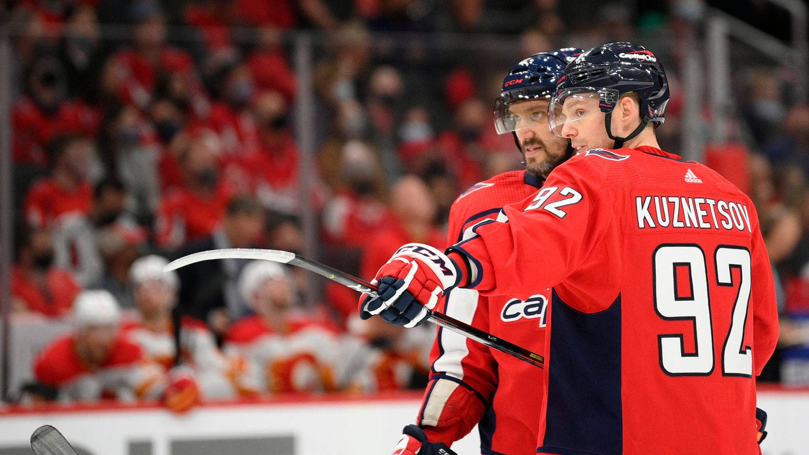 Evgeny Kuznetsov 冷靜戰術 壁紙 — 兩名身穿紅色球衣、號碼92、名字KUZNETSOV的冰球運動員在比賽中於冰上慶祝，背景有球迷。