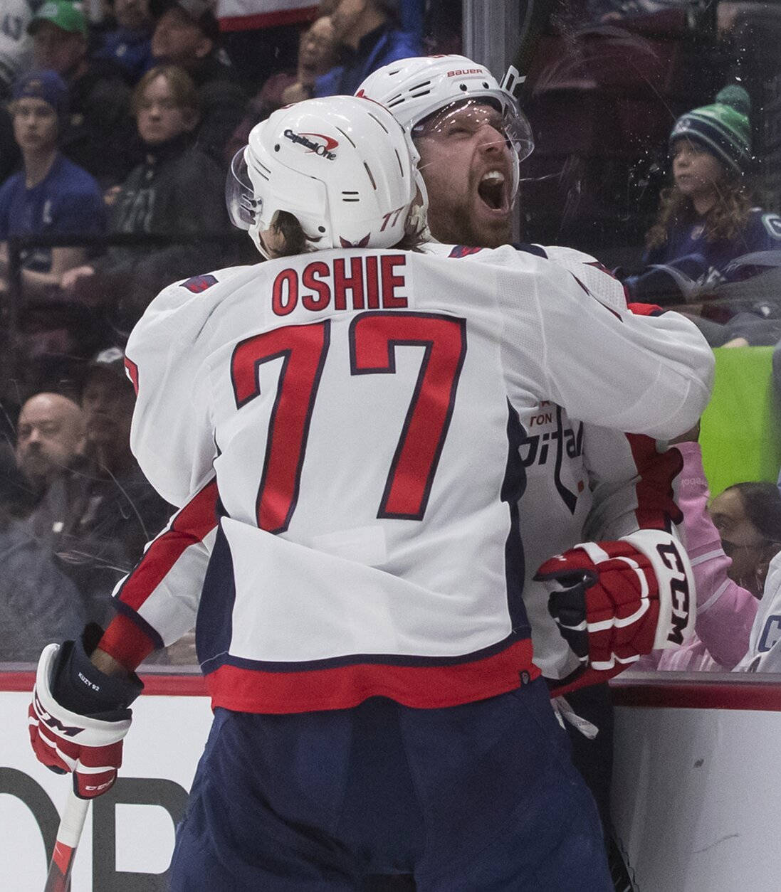 Evgeny Kuznetsov 勝利比賽 壁紙 — 兩名身穿白色球衣、紅色號碼的冰球運動員在比賽中於冰上熱情慶祝。