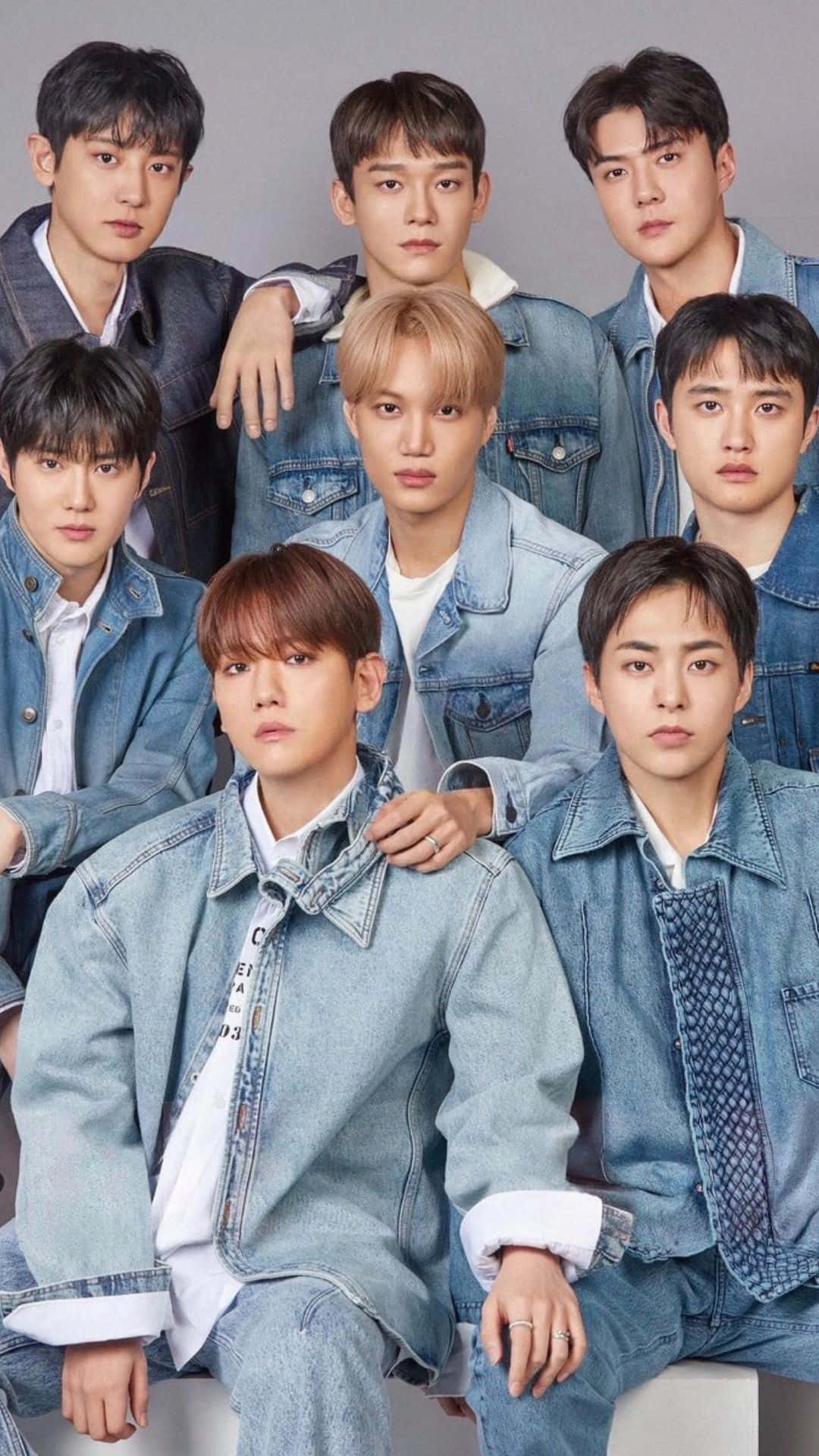 EXO 演唱會現場合照 壁紙 — 七位身穿牛仔外套的年輕男性在灰色中性背景的攝影棚肖像中自信地擺姿勢。