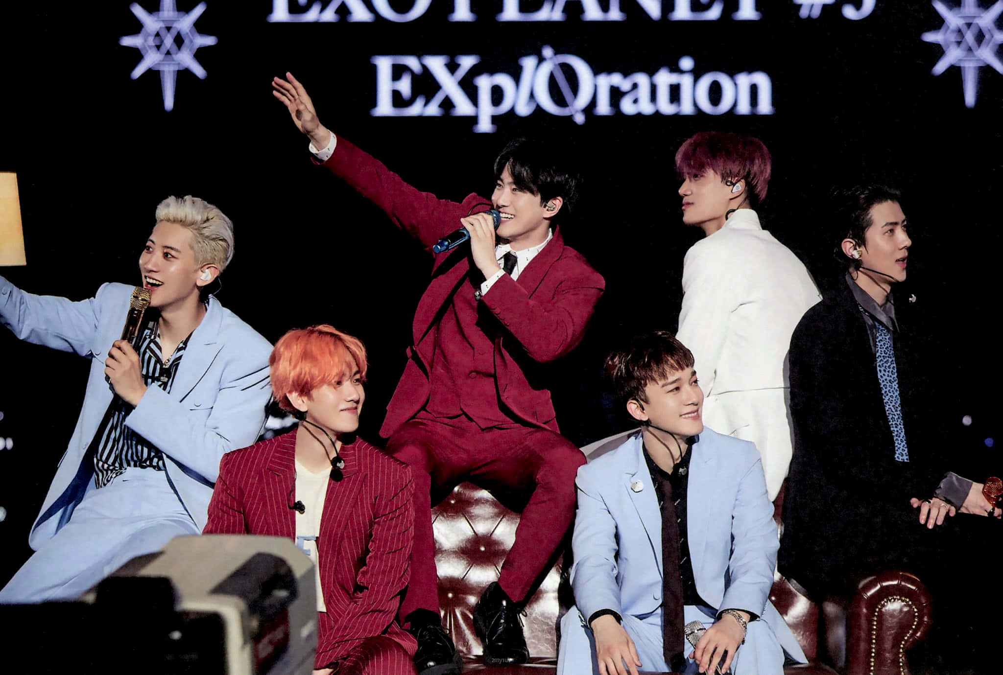 EXO舞台演出配燈光煙霧效果 壁紙 — 六位身穿時尚西裝的男性K-pop偶像在「EXO PLANET #3 EXplOration」背景的舞台上充滿活力地表演。