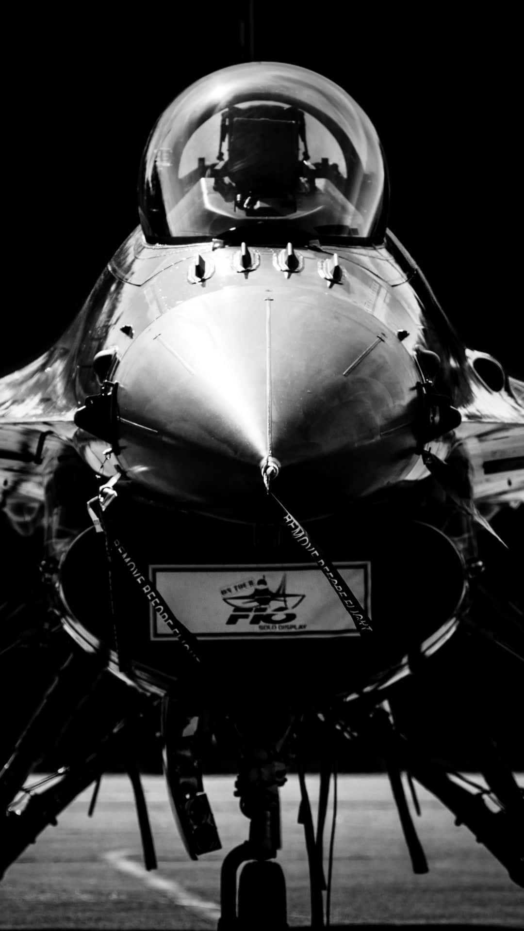 黑色F-16戰隼安卓巨無霸背景 壁紙 — 停機坪上戰鬥機駕駛艙和機鼻錐的戲劇性黑白特寫。
