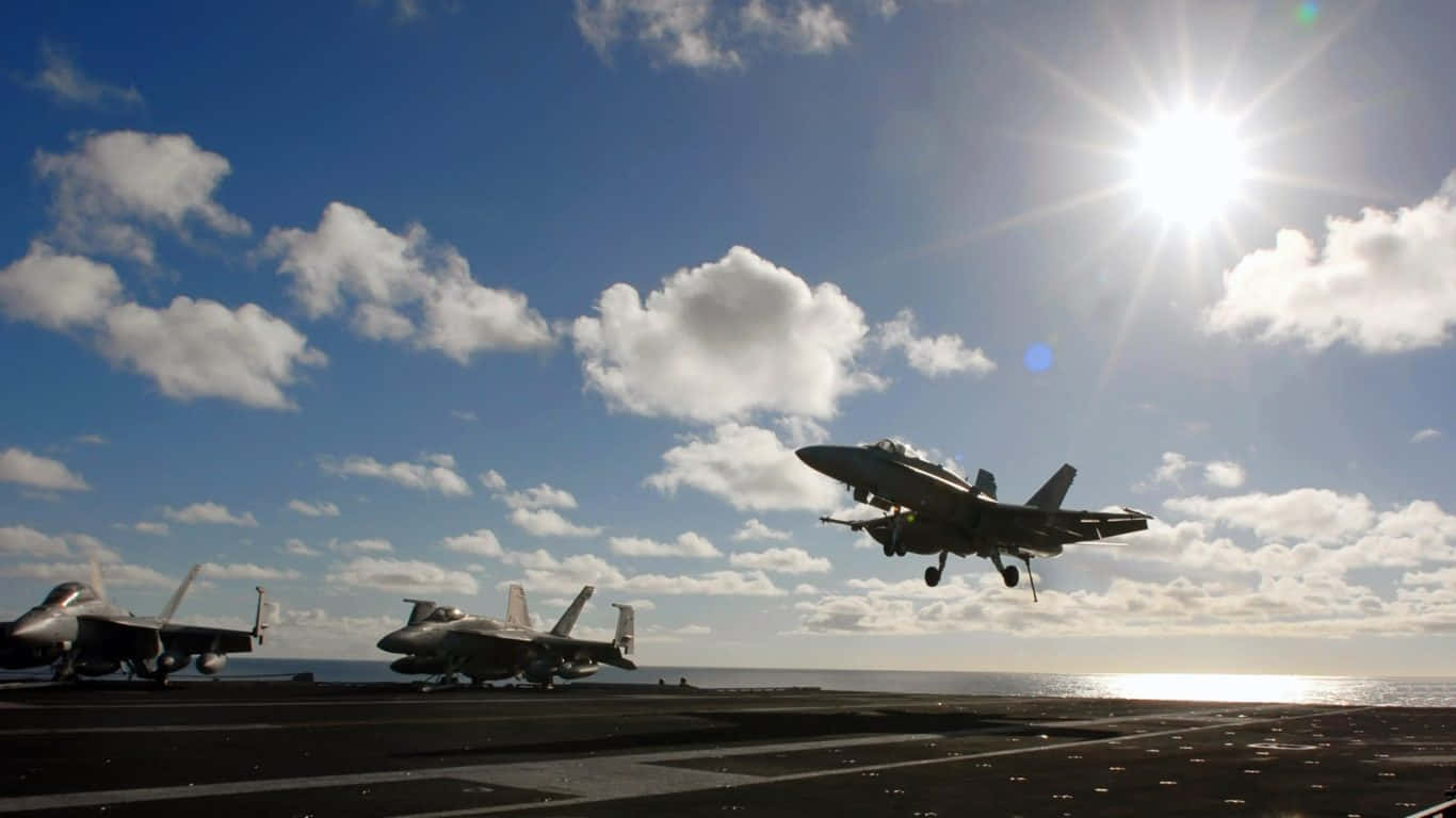 F-18 猛禽艦載機降落於航空母艦跑道的巨型客機背景（1366x768） 壁紙 — 一架戰鬥機在明亮的陽光、散落的雲朵和海洋地平線下從航空母艦甲板起飛。