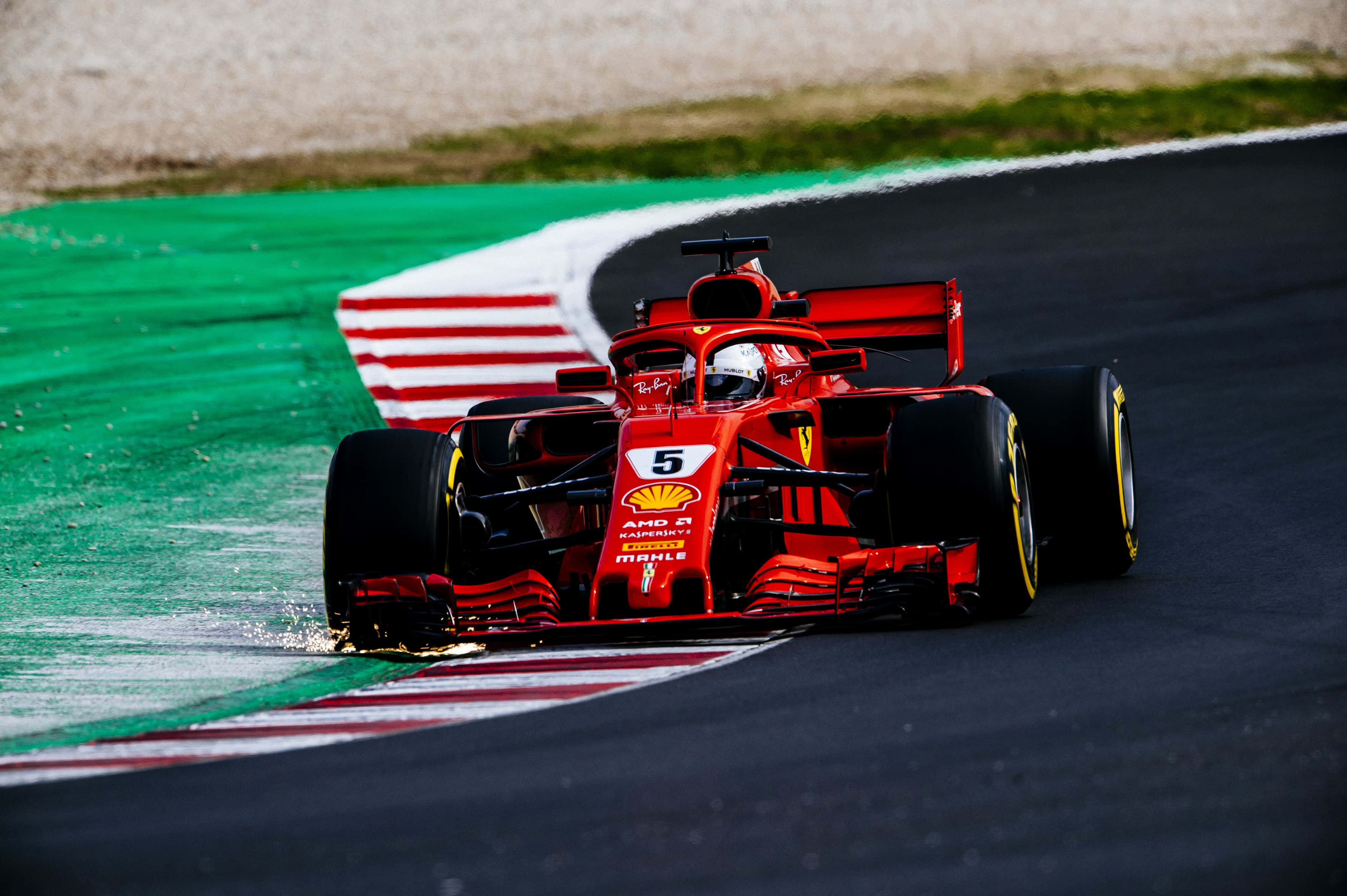 塞巴斯蒂安·維特爾法拉利賽車 F1 2018 背景 壁紙 — 一輛紅色法拉利一級方程式賽車，車號5，在濕滑賽道上緊貼著綠色和紅色路肩飛馳。