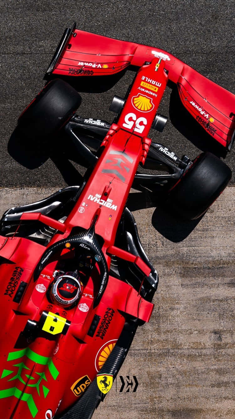 「速度與精準：法拉利 F1 賽車」 壁紙 — 一輛紅色法拉利F1賽車（55號）停在瀝青路面上的鳥瞰圖，展示了贊助商標誌和空氣動力學設計。