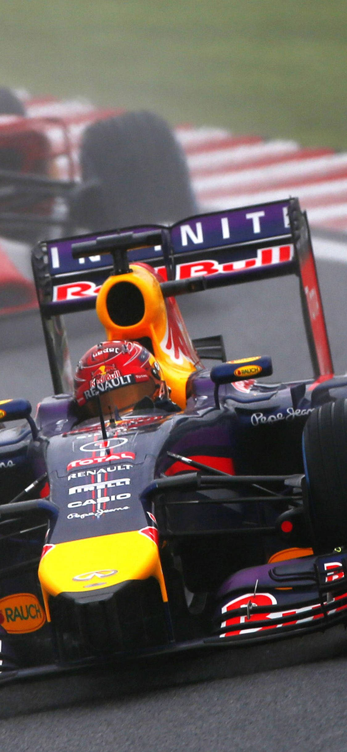 F1 丹尼爾·里卡多賽車 iPhone 壁紙 — 一輛紅牛一級方程式賽車在潮濕的賽道上疾馳，帶有動態模糊效果，贊助商標誌清晰可見。
