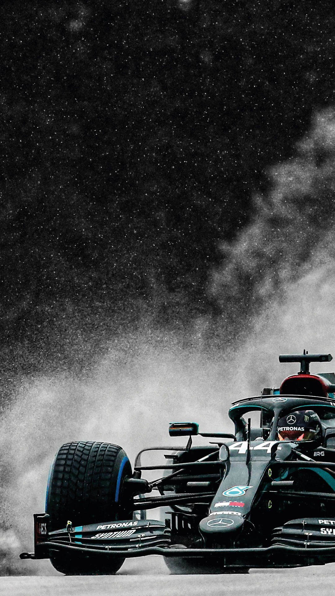黑色和青綠色的F1賽車在夜雨中飛馳。