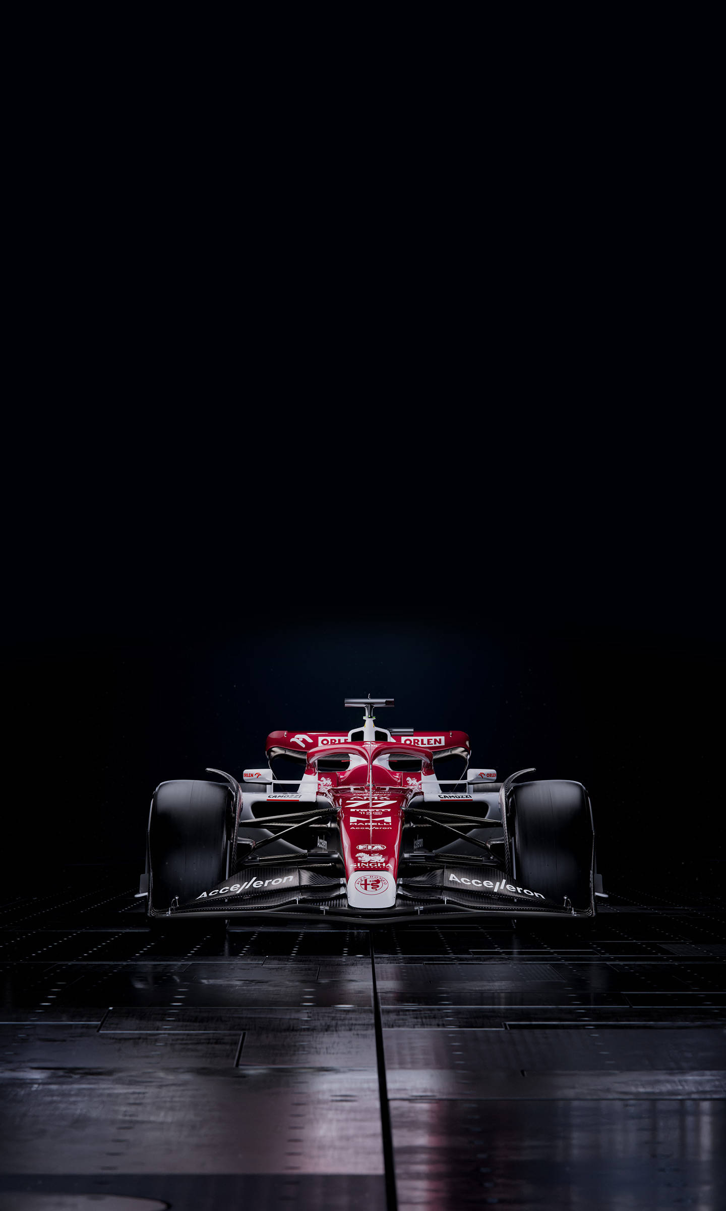 F1 阿爾法·羅密歐 C42 iPhone 壁紙 — 一輛紅白相間的一級方程式賽車在黑暗反光網格地板上被聚光燈照亮。