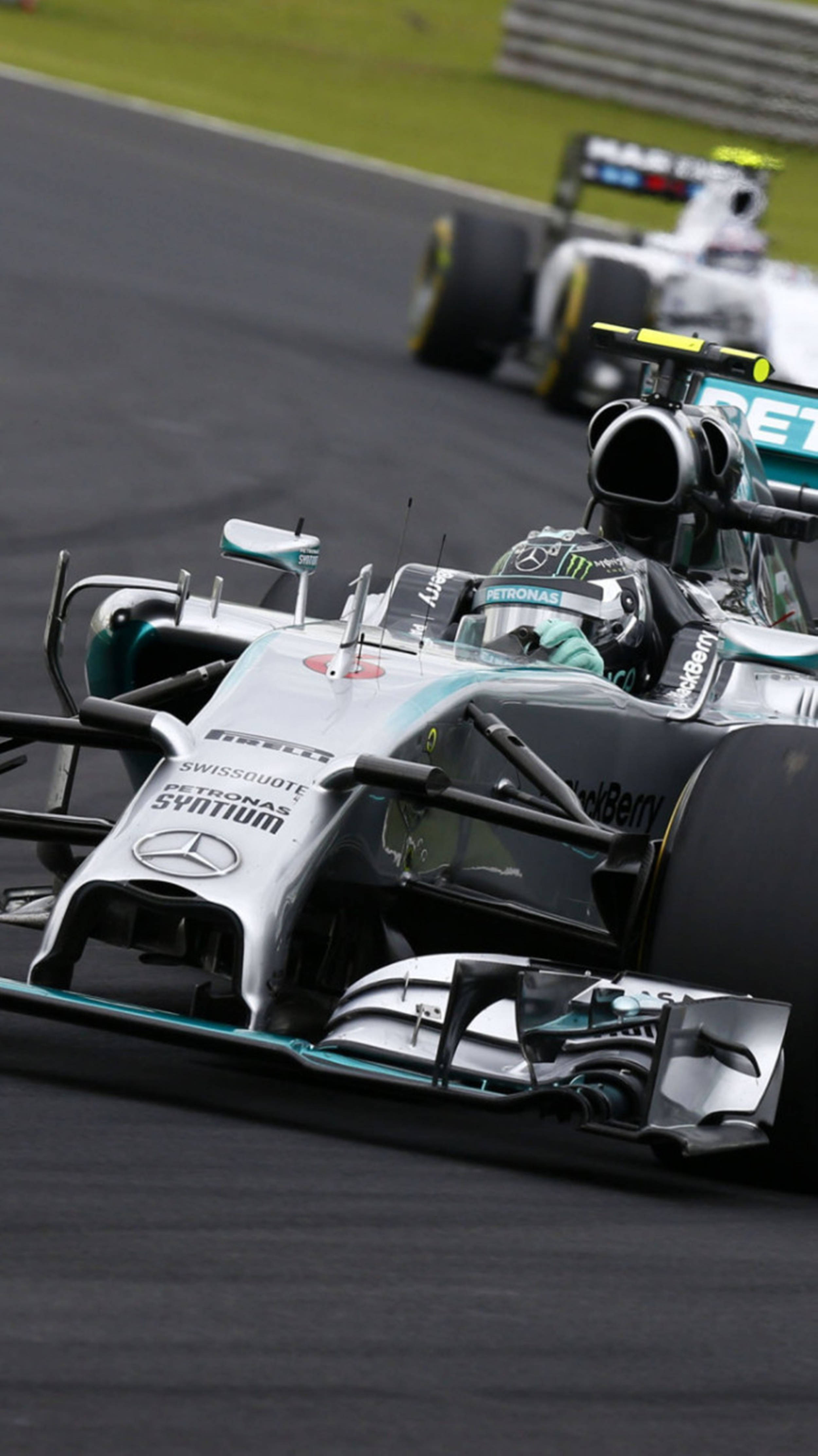 加速投入F1賽車的刺激世界——流線型白色賽車F1手機 壁紙 — 一輛平治一級方程式賽車在賽道上飛馳，背景中可見另一競爭對手。