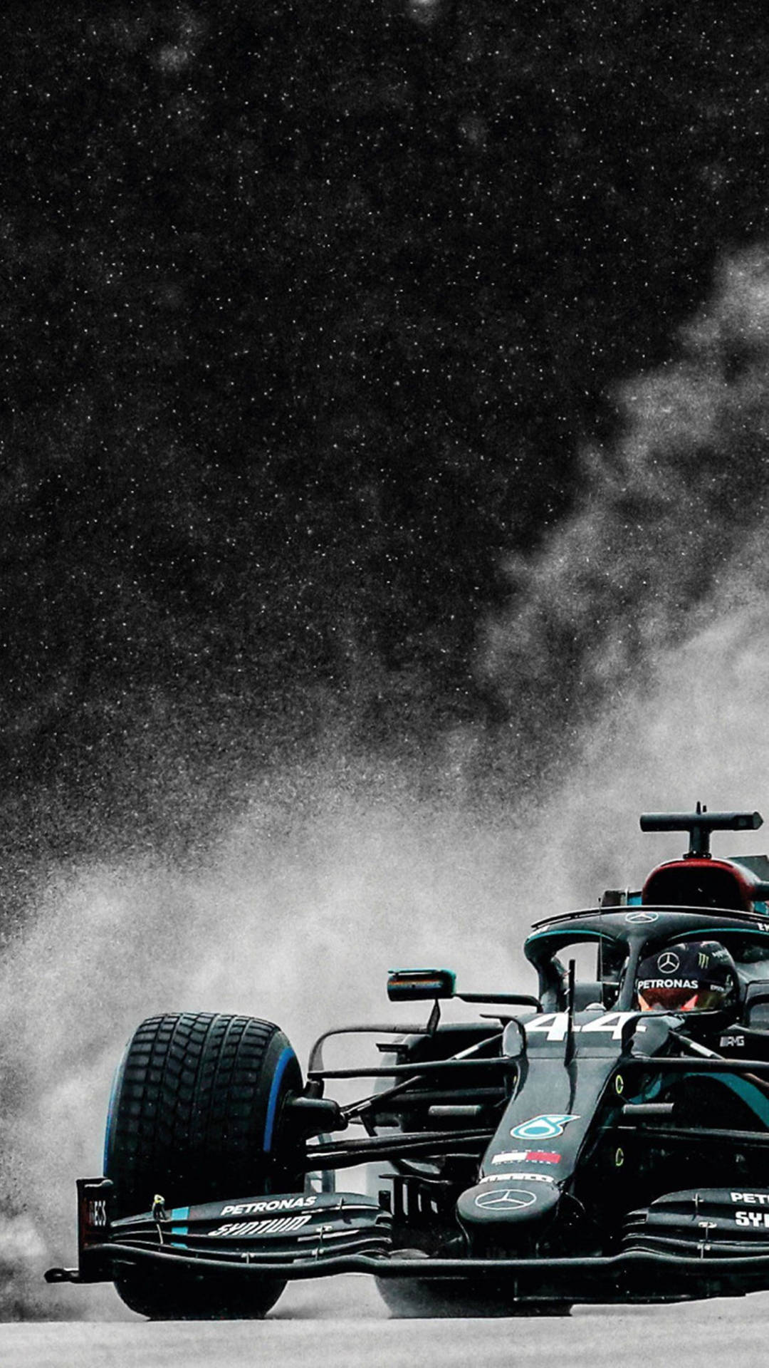 F1手機壁紙：黑色梅賽德斯賽車 壁紙 — 一輛黑色和藍綠色的F1賽車在繁星點點的夜空下揚起塵土，煙霧在車尾盤旋。