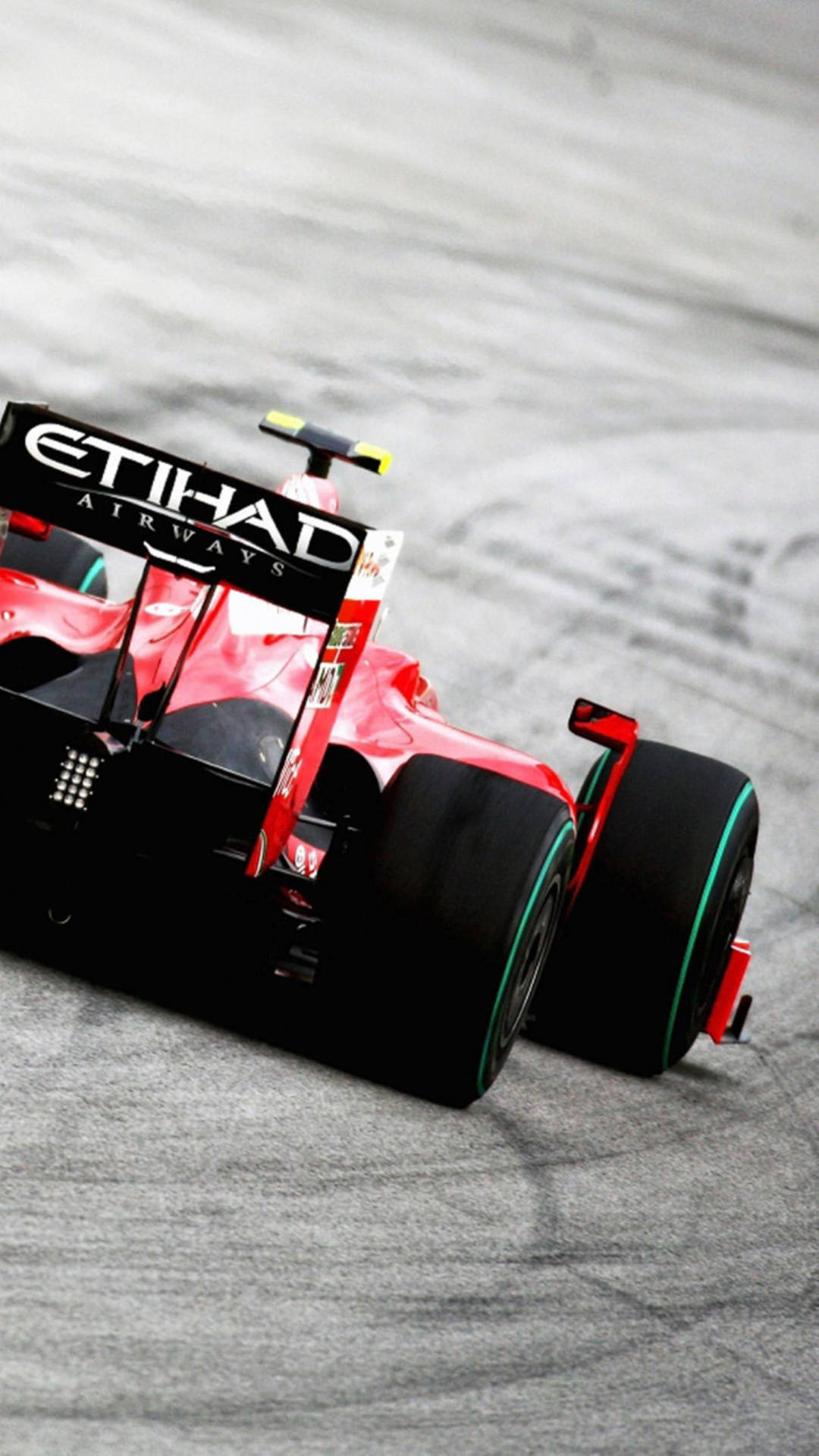 F1手機艾提哈德紅色賽車賽事 壁紙 — 一輛帶有阿提哈德航空品牌標誌的紅黑色一級方程式賽車在灰色賽道表面上疾馳。