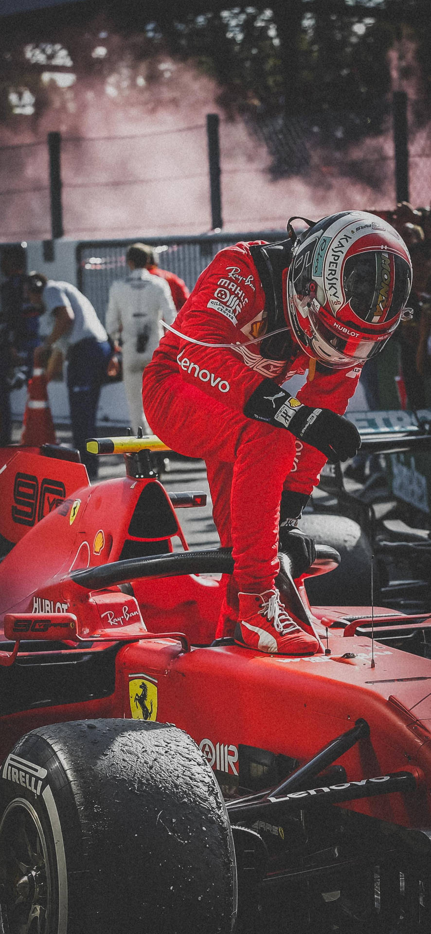 F1車手夏爾·勒克萊爾駕車離場動作照 壁紙 — 一位身穿紅色賽車裝備的F1車手俯身靠在他的紅色法拉利賽車上，身後煙霧升騰。