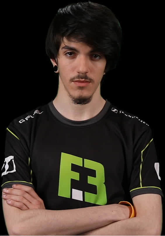 身穿F3球衣的電競選手 壁紙 — 一位黑髮留鬚的年輕男子自信地交叉雙臂站立，身穿黑色電競球衣，帶有亮綠色F3標誌，背景為黑色。