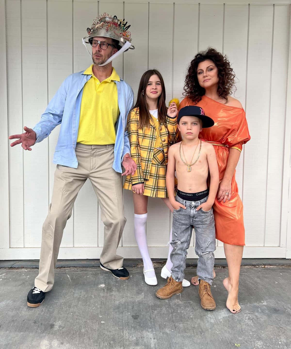tiffani thiessen 桌布 壁紙 — 一個四口之家穿著古怪的服裝，在白色車庫門前擺出俏皮的表情。