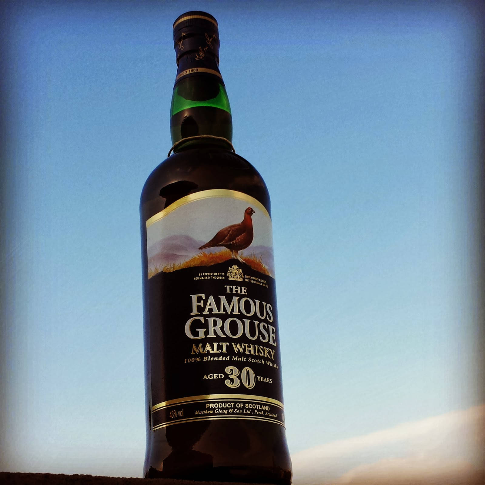一瓶 Famous Grouse 30 年威士忌，以藍天為背景。