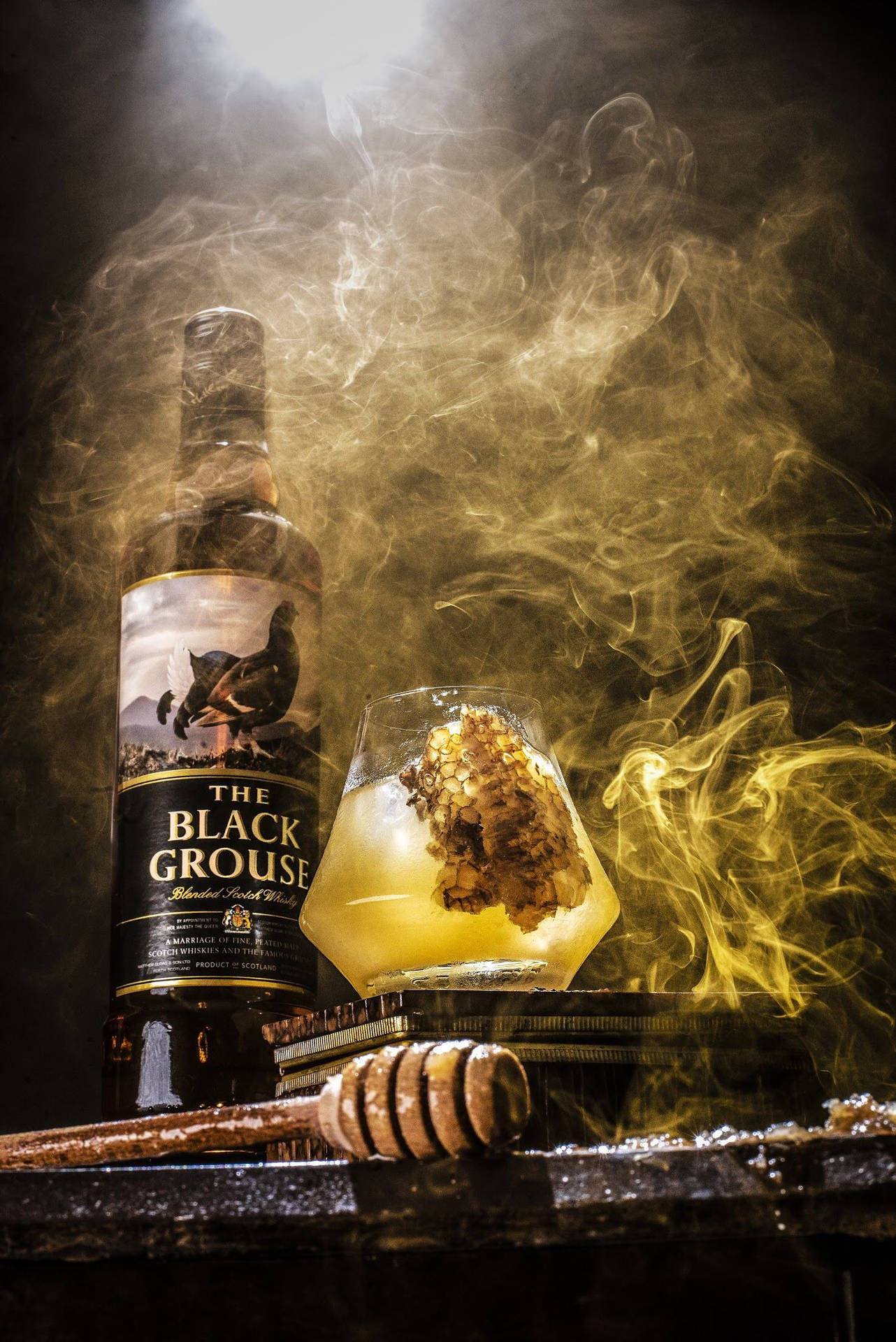 Black Grouse威士忌瓶和蜂巢雞尾酒，帶煙霧，木桌