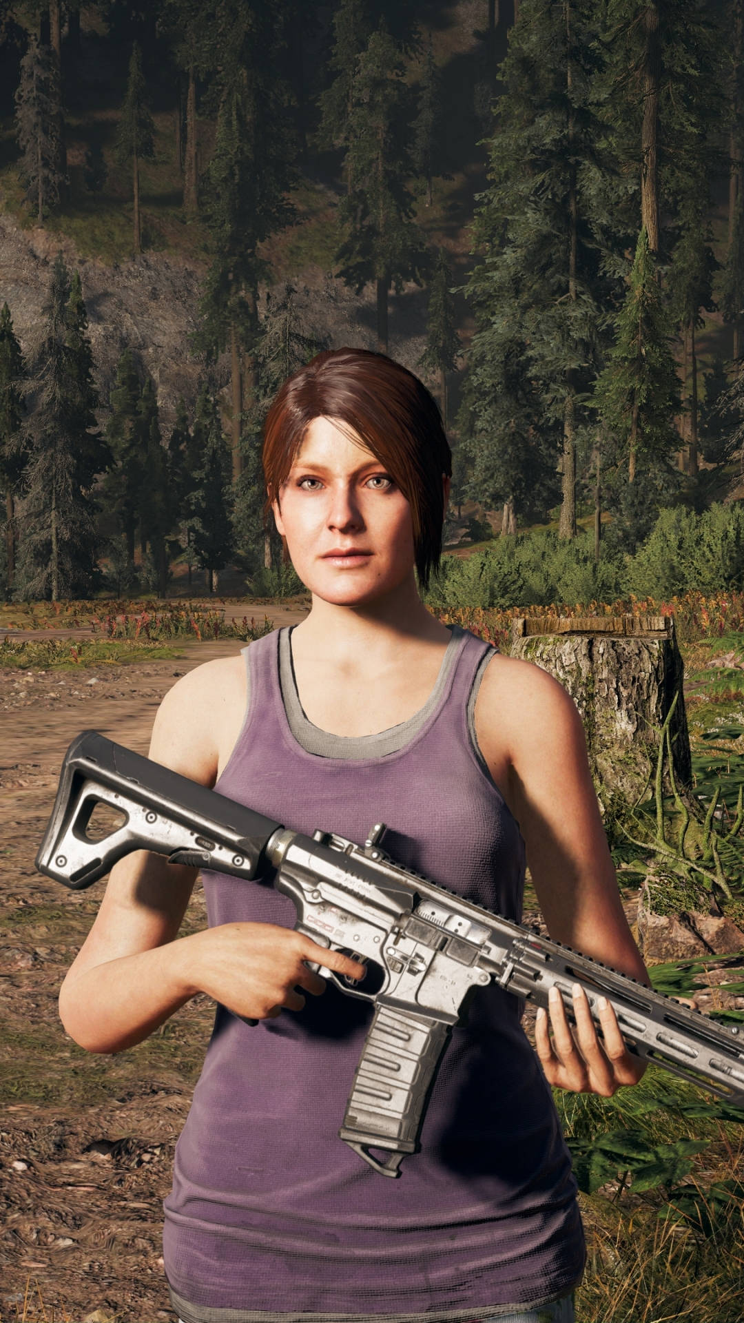 Far Cry 5：Jess Black 持槍 iPhone 壁紙 — 一位身穿紫色背心的女性在陽光明媚的森林空地中持步槍，周圍有高大的松樹和一條泥土小徑。