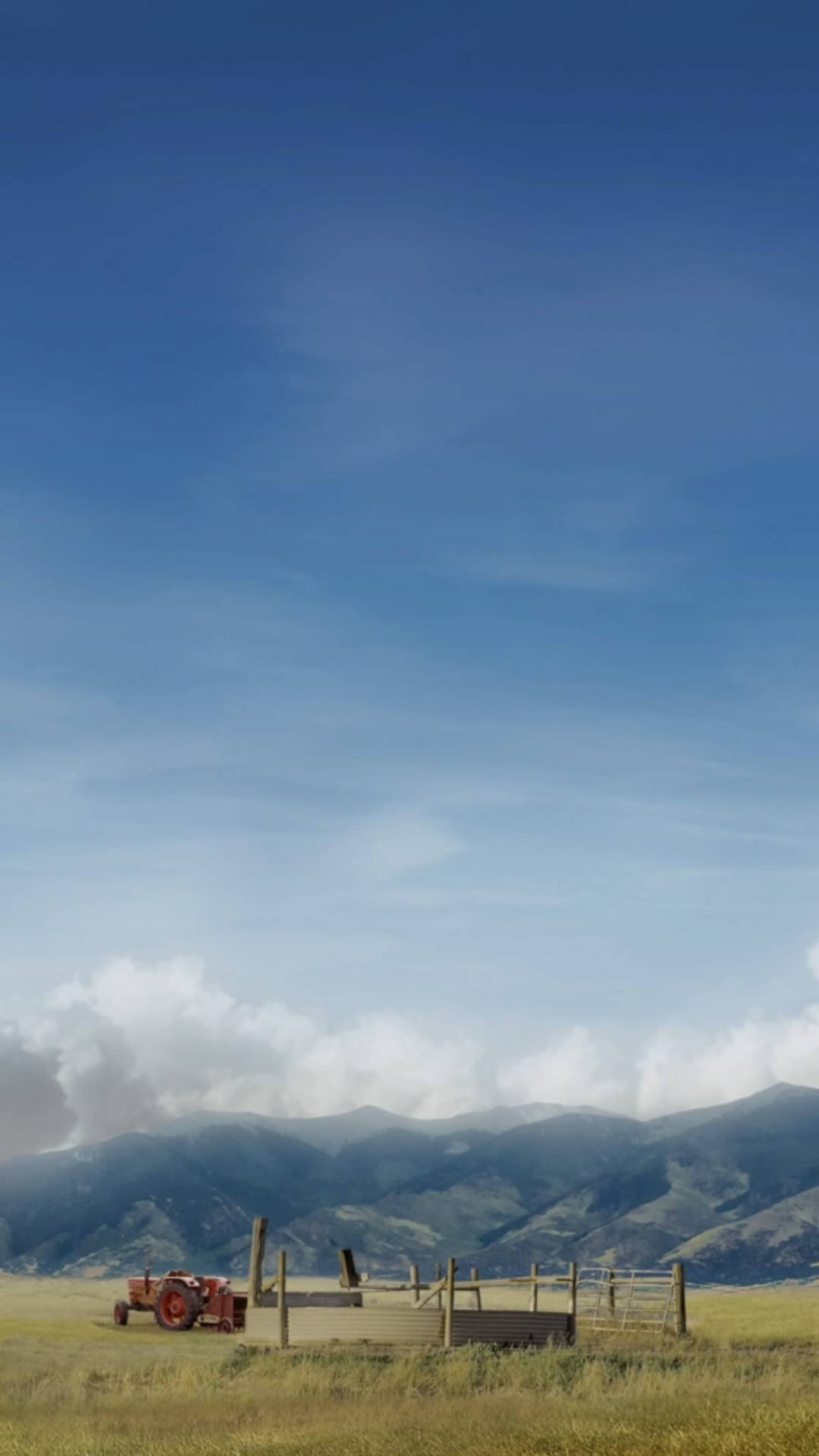 Far Cry 5 農田 iPhone 壁紙 — 一架復古紅色拖拉機停在一片金色田野中，背景是遠方的綠色山脈，上方是廣闊的藍天和縷縷白雲。