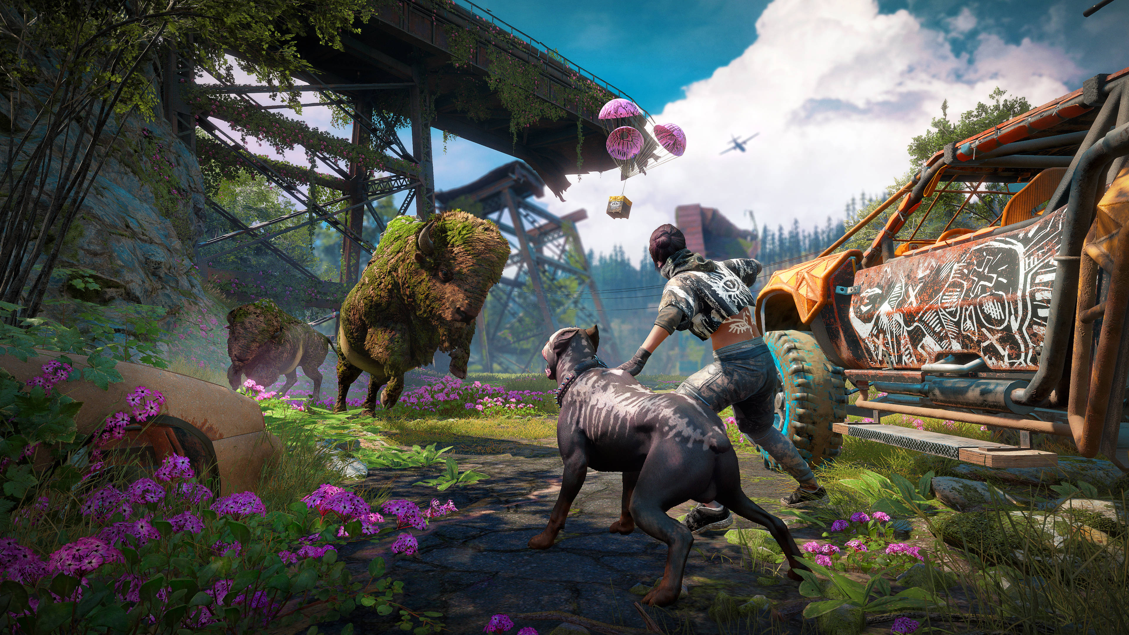 Far Cry New Dawn 巨型野牛 壁紙 — 一個人帶著狗在明亮的天空下探索一個生機勃勃、雜草叢生的垃圾場，有紫色花朵和長滿苔蘚的野牛。