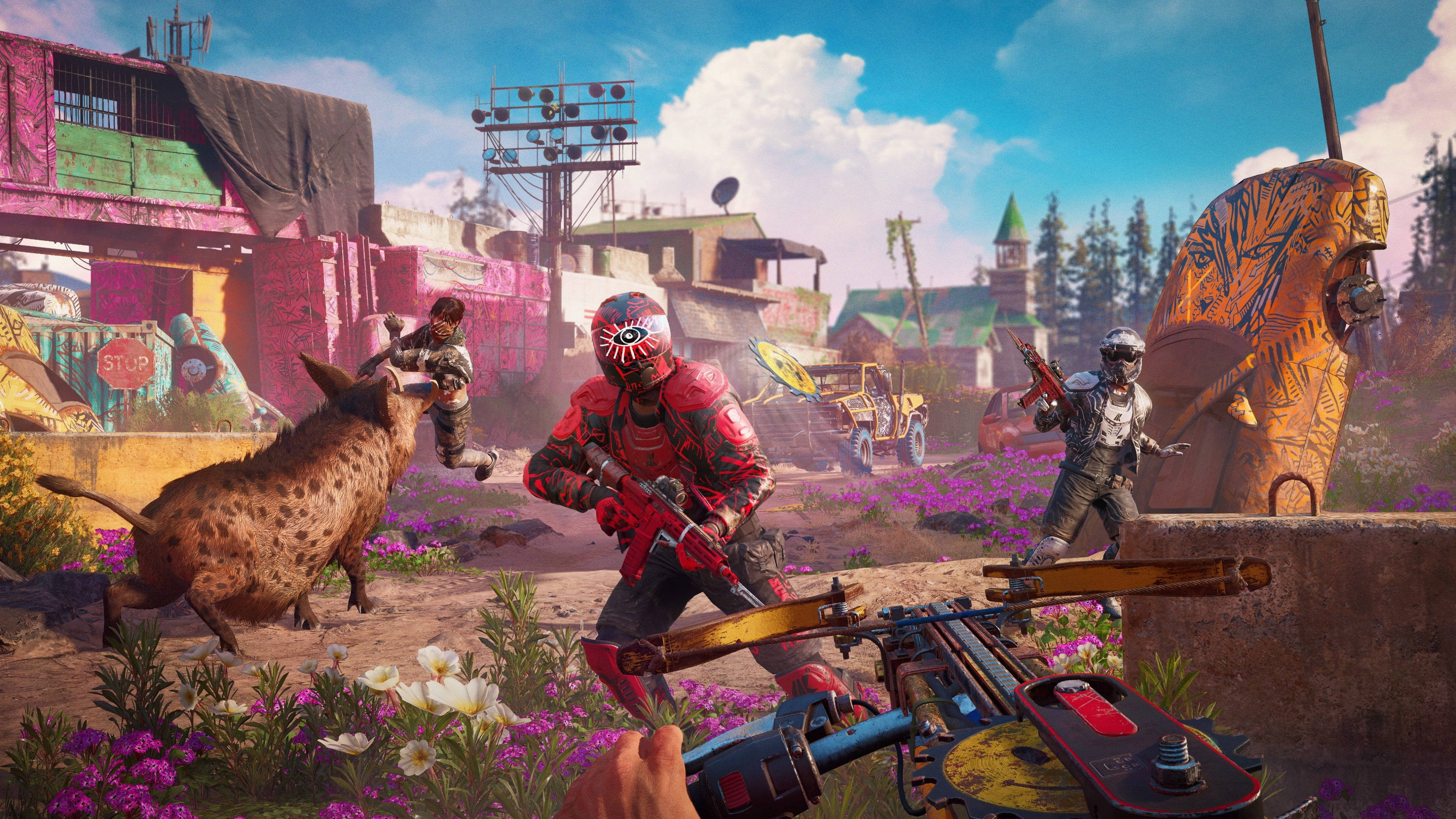 《Far Cry New Dawn》鋸式發射器 壁紙 — 玩家身穿鮮豔裝備，在一個充滿花朵和塗鴉、色彩繽紛且混亂的末世村莊中與野豬搏鬥。