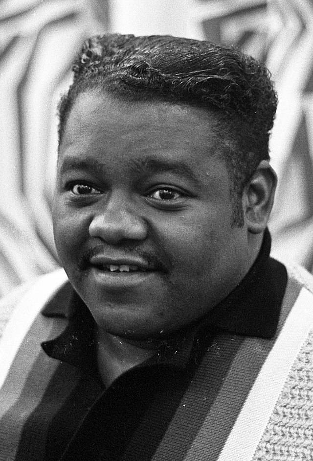 Fats Domino 近照 壁紙 — 一個微笑留鬍鬚的男人穿著條紋毛衣的黑白肖像。