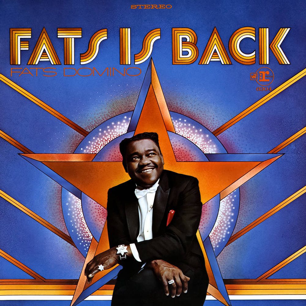 Fats Domino回歸專輯封面「Fats is Back」 壁紙 — Fats Domino 身穿燕尾服，在充滿活力的藍色和橙色星爆圖案專輯封面背景下自信微笑。