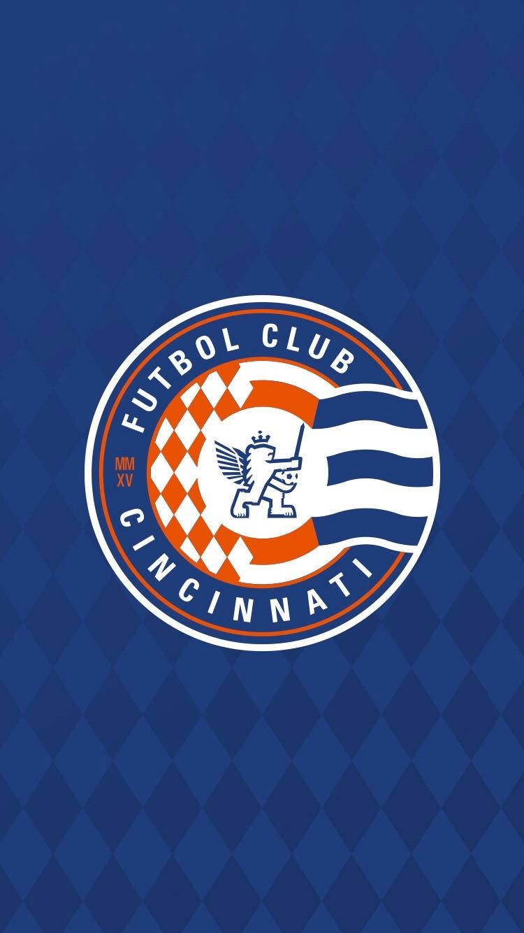 FC辛辛那提新俱樂部標誌 壁紙 — Futbol Club Cincinnati 標誌居中於藍色菱形圖案背景上。