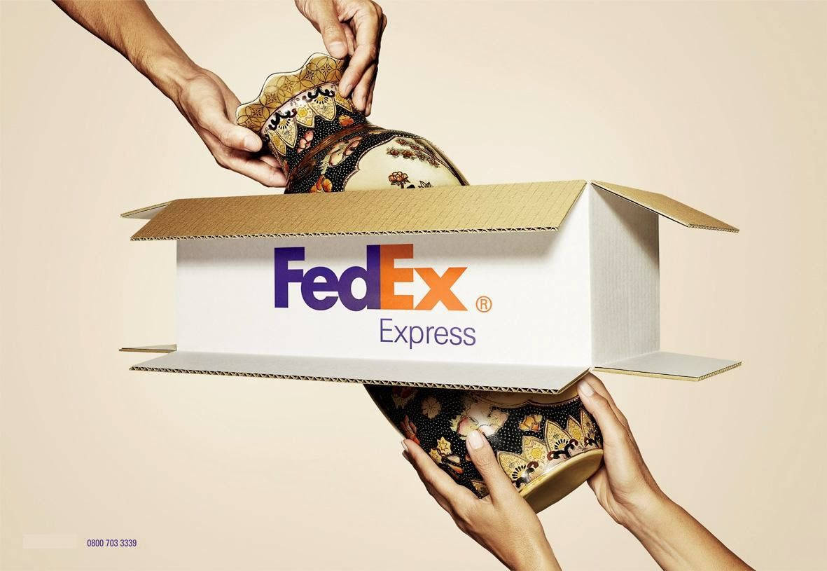 兩隻手在FedEx Express運輸箱內處理一個裝飾花瓶。