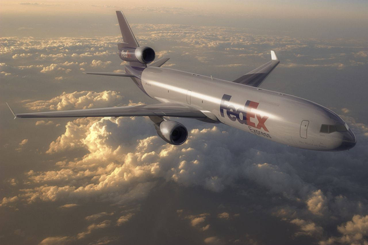 FedEx客機飛越雲層 壁紙 — 一架聯邦快遞貨機在日出時翱翔於金色雲層之上，機身散發溫暖光芒。