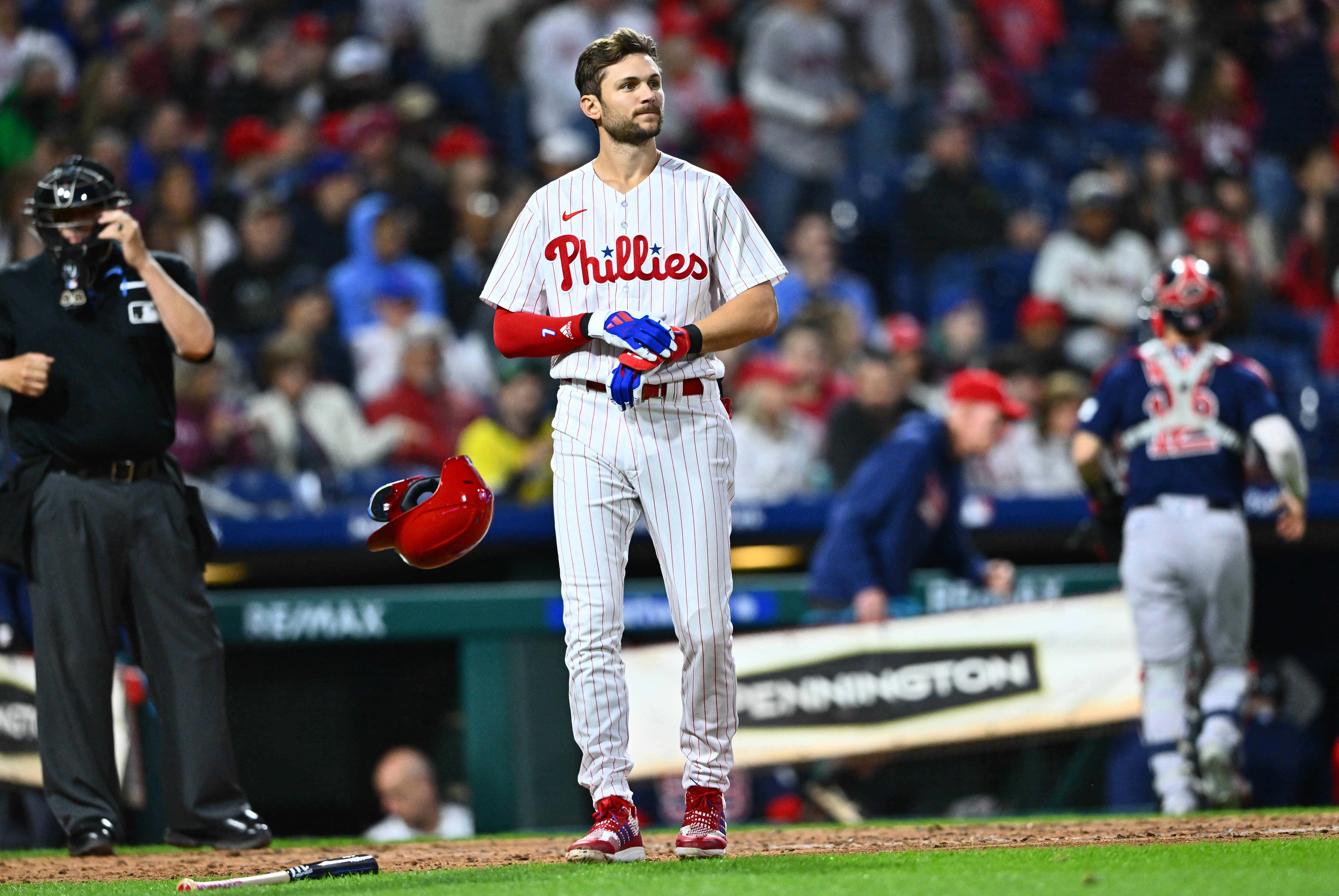 Trea Turner Phillies 桌布 壁紙 — 一名費城費城人棒球選手在球場燈光下比賽後站在場上手持頭盔。