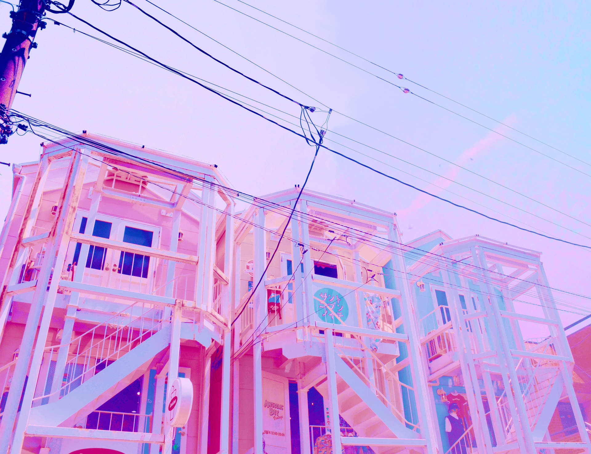 粉彩色的城市建築物，設有外部樓梯和架空電線。