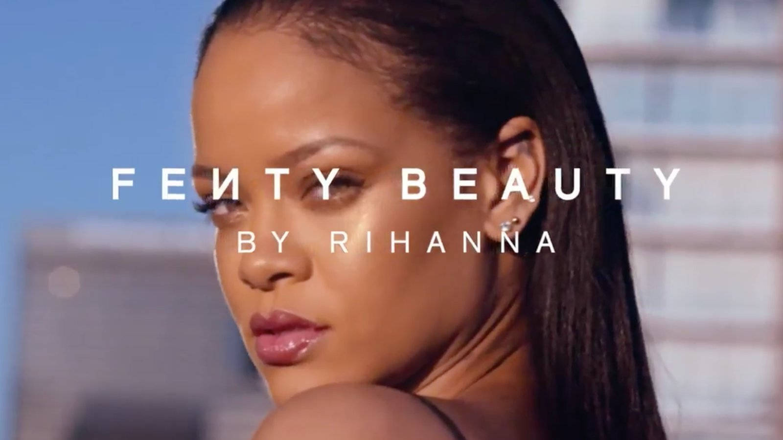 Rihanna 在美容廣告中，背景為城市和文字疊加。