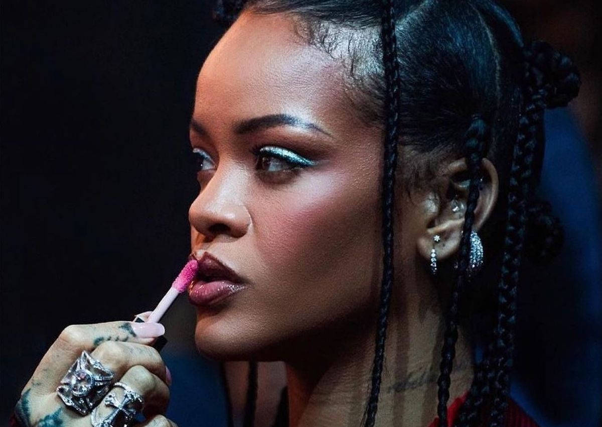 Rihanna 塗上粉紅色唇彩，搭配辮子頭髮和閃亮眼睛。