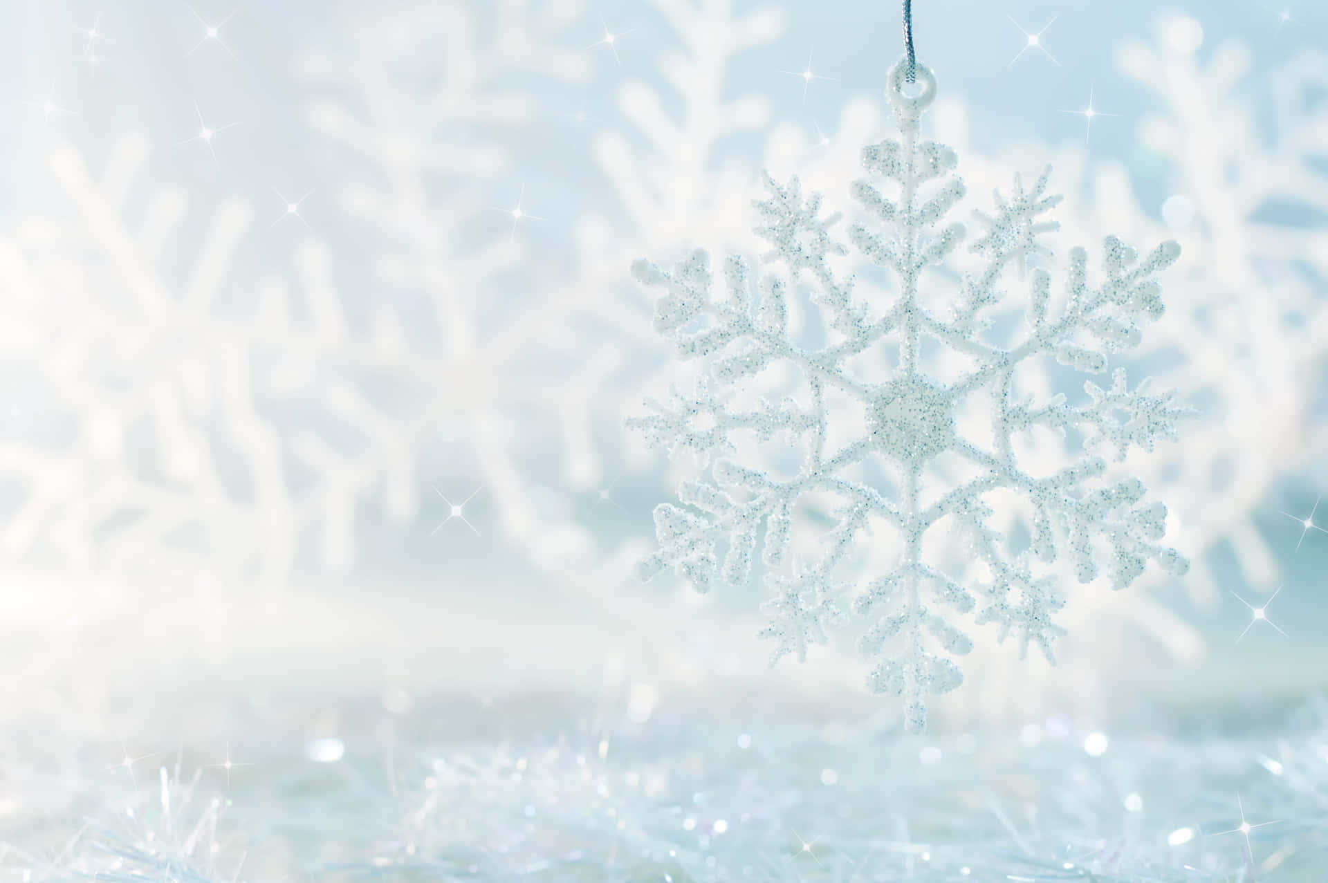 一個懸掛的閃亮雪花裝飾品，在冬季場景中閃爍。