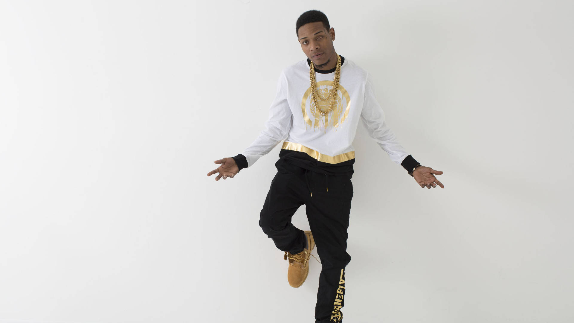 Fetty Wap 美學攝影 壁紙 — 一名戴著金鏈條、身穿白恤衫的男子，在純白色攝影棚背景前擺出動感姿勢。