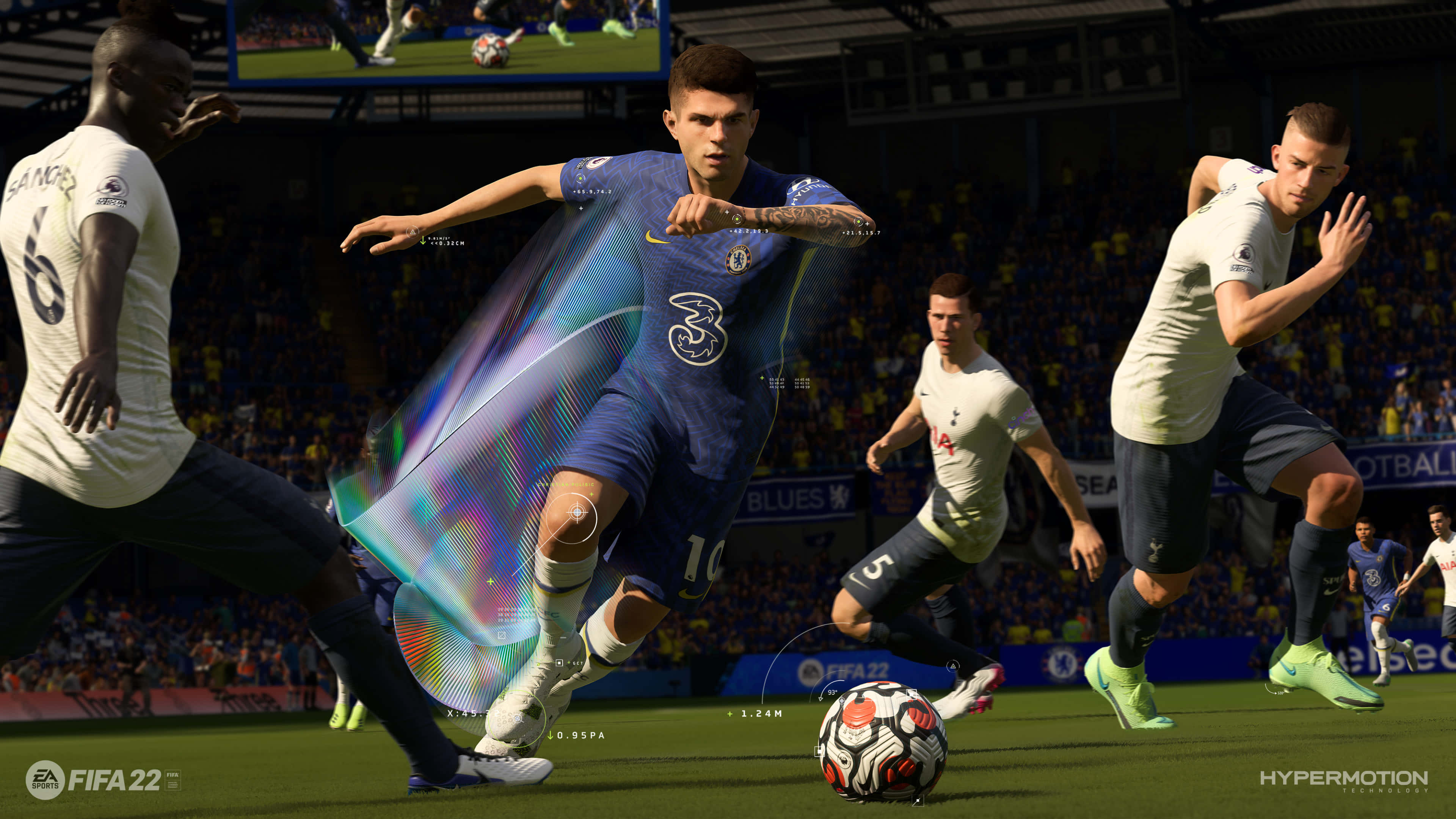 FIFA 22 現代遊戲平台精彩對戰 壁紙 — 一名身穿蓝色球衣的足球运动员在座无虚席的体育场比赛中，用腿周围发光的彩虹效果运球。