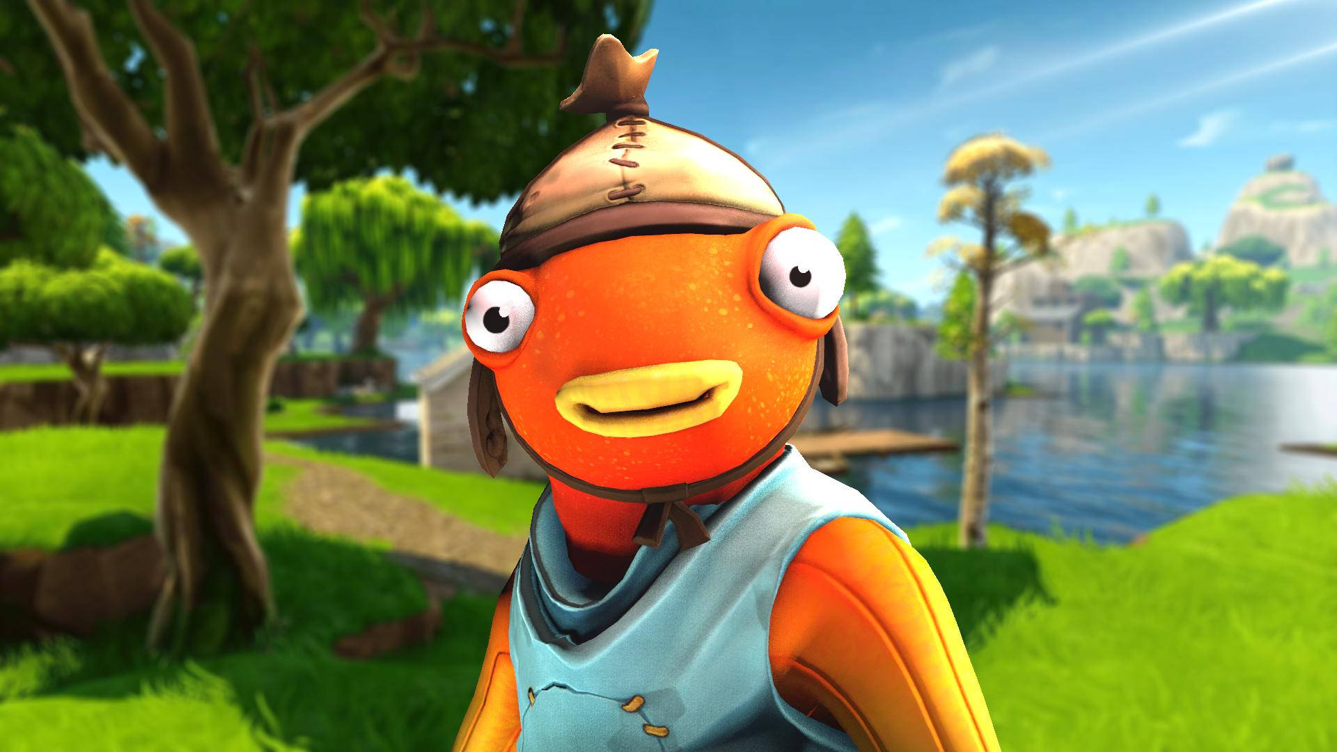 Fishstick Fortnite 微笑 壁紙 — 一個戴帽子和背心的開心橙色魚角色站在有樹木和水的明亮陽光戶外場景中。