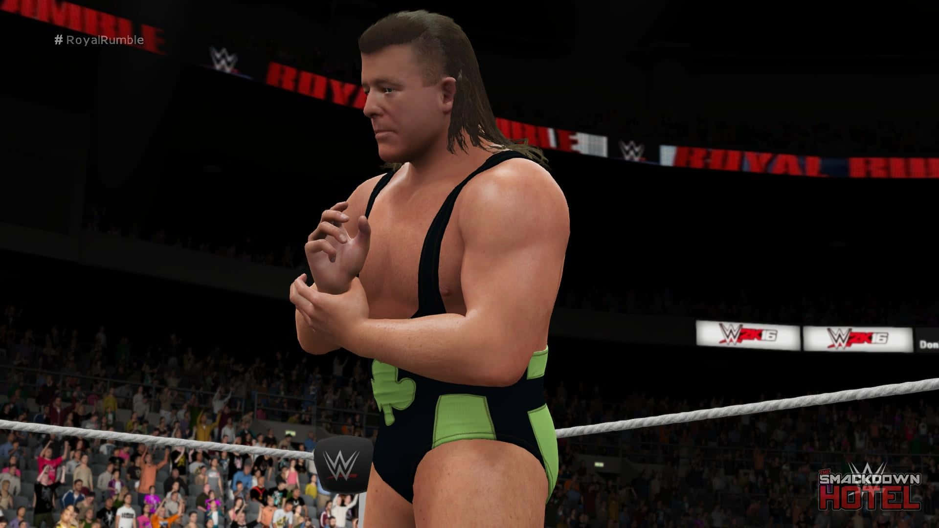 Fit Finlay WWE 2K16 名單皇家大戰 壁紙 — 身穿黑色和綠色短褲的摔角手站在擂台上，在明亮的場館燈光下，觀眾歡呼雀躍。
