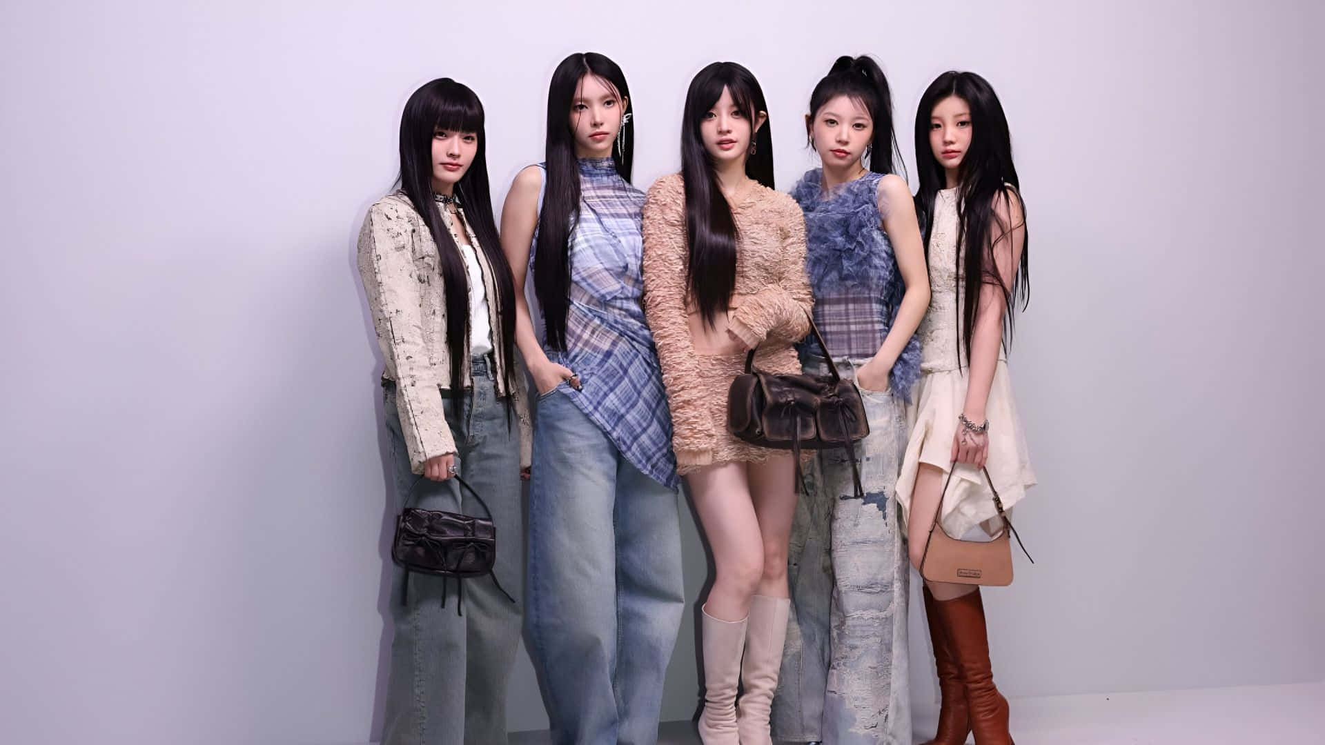  壁紙 — 五位時尚女性穿著潮流服裝，自信地在純白色工作室牆前擺姿勢。